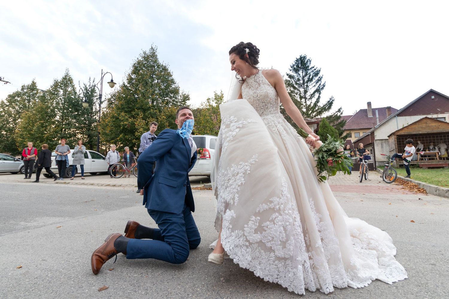 Romantic wedding moment captured outdoors with elegant white lace dress.