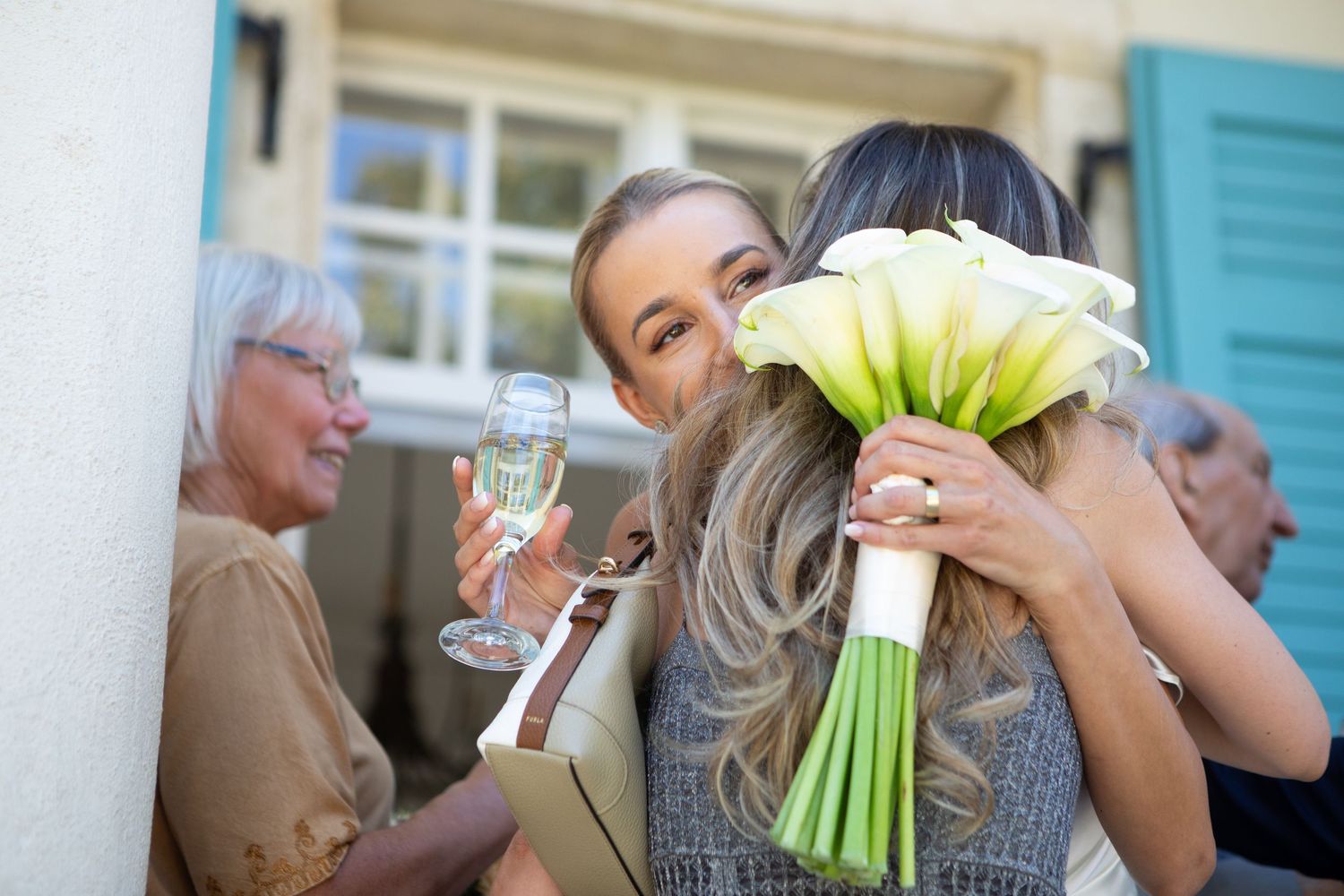 Guests enjoying drinks and conversation at an outdoor wedding celebration.