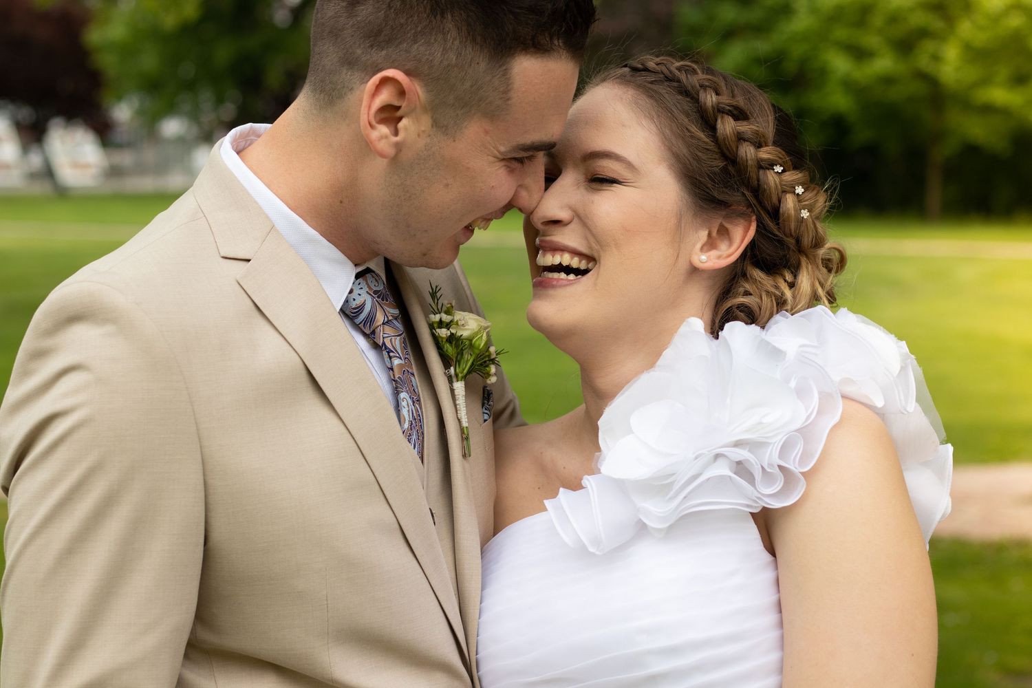 Intimate wedding portrait captured in a sunlit garden setting.