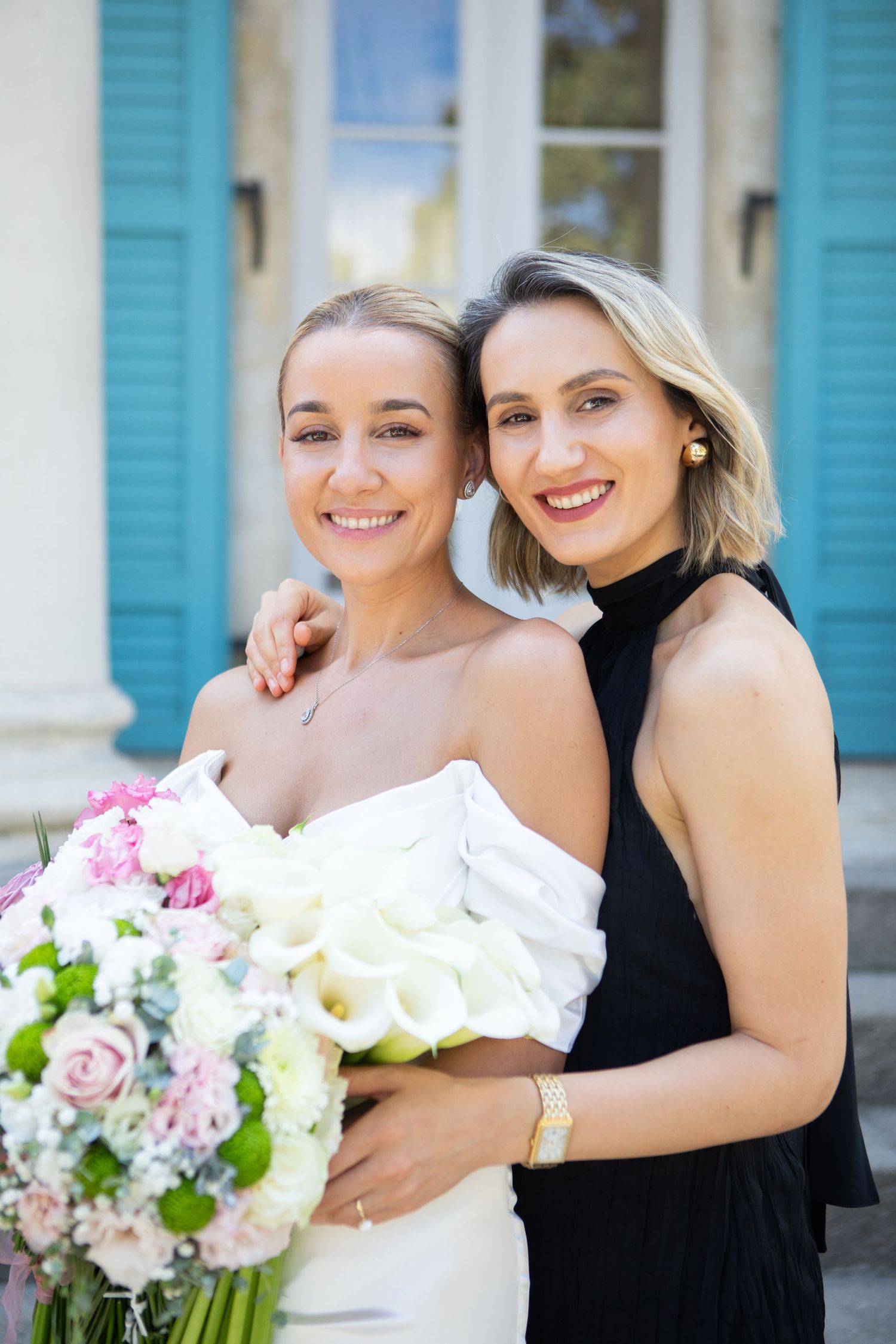 Wedding party members holding beautiful pink and white floral bouquets.