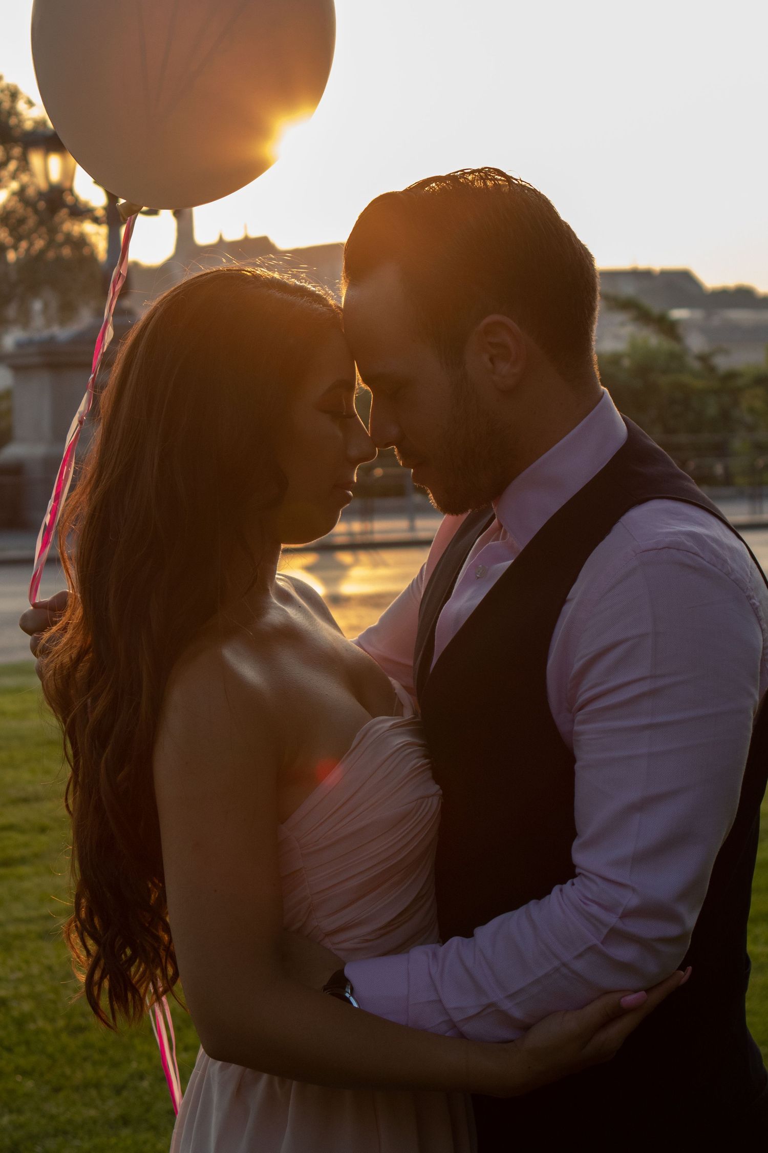 Silhouette of a couple embracing during golden hour sunset outdoors.