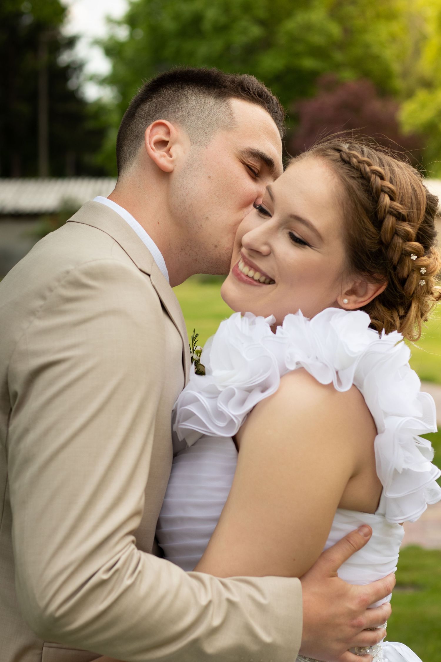 Romantic moment between newlyweds in a garden setting with soft natural lighting.