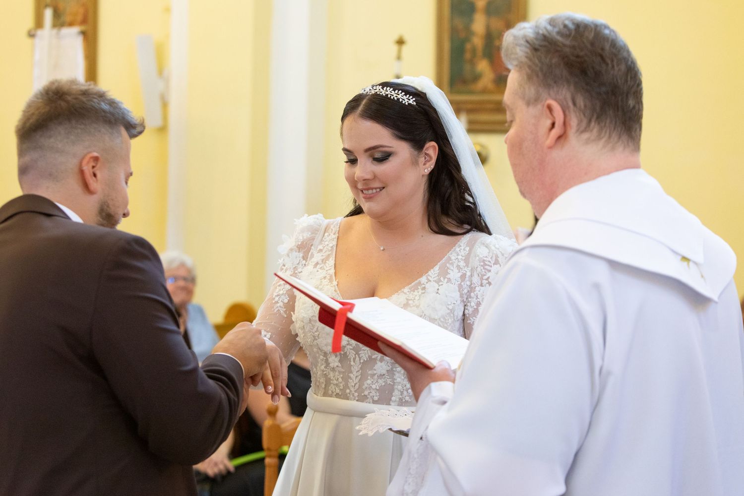 Traditional church wedding ceremony with white lace dress and religious officiant.