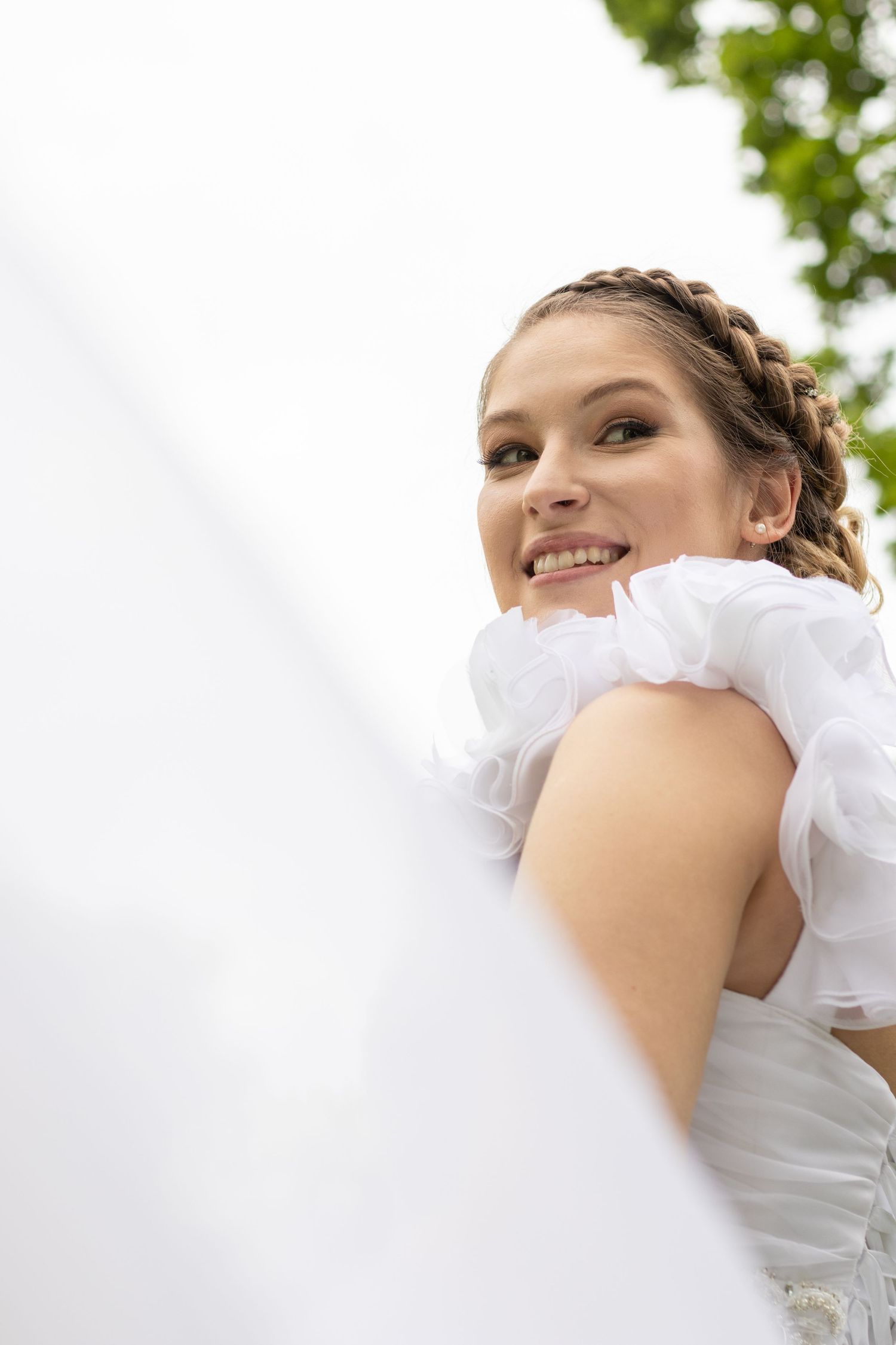 Close-up view of a white wedding dress with delicate ruffles and details.