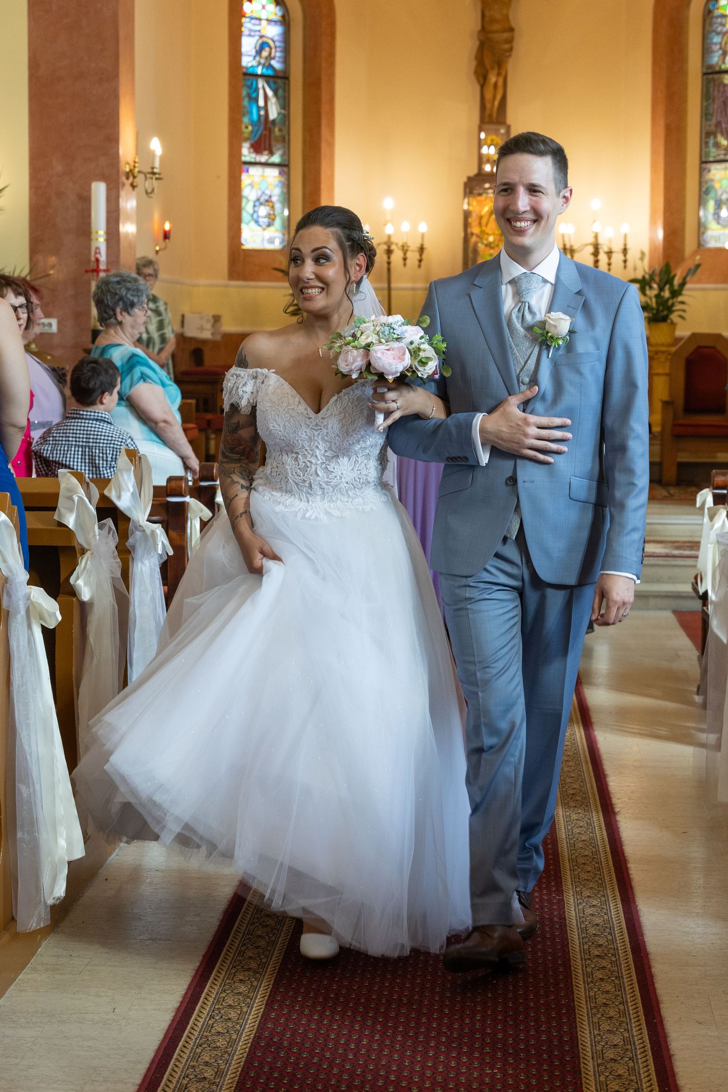 A wedding celebration inside a church with ornate decorations and stained glass windows.