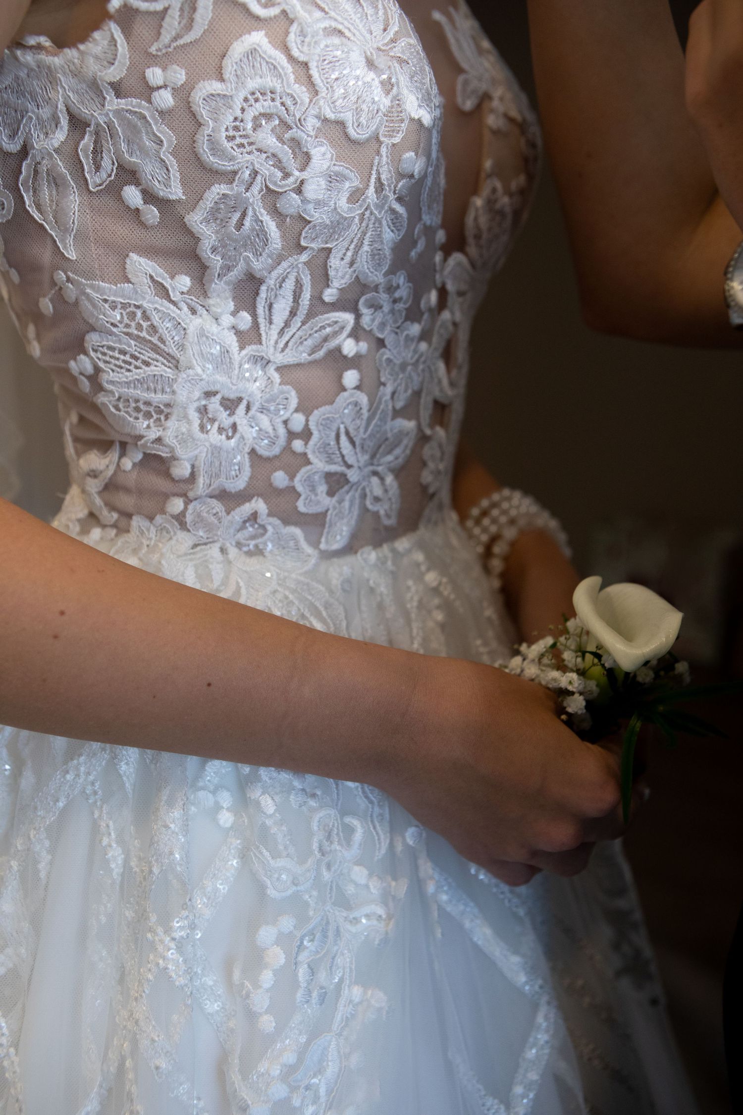 Detailed shot of intricate lace bodice on white wedding gown.