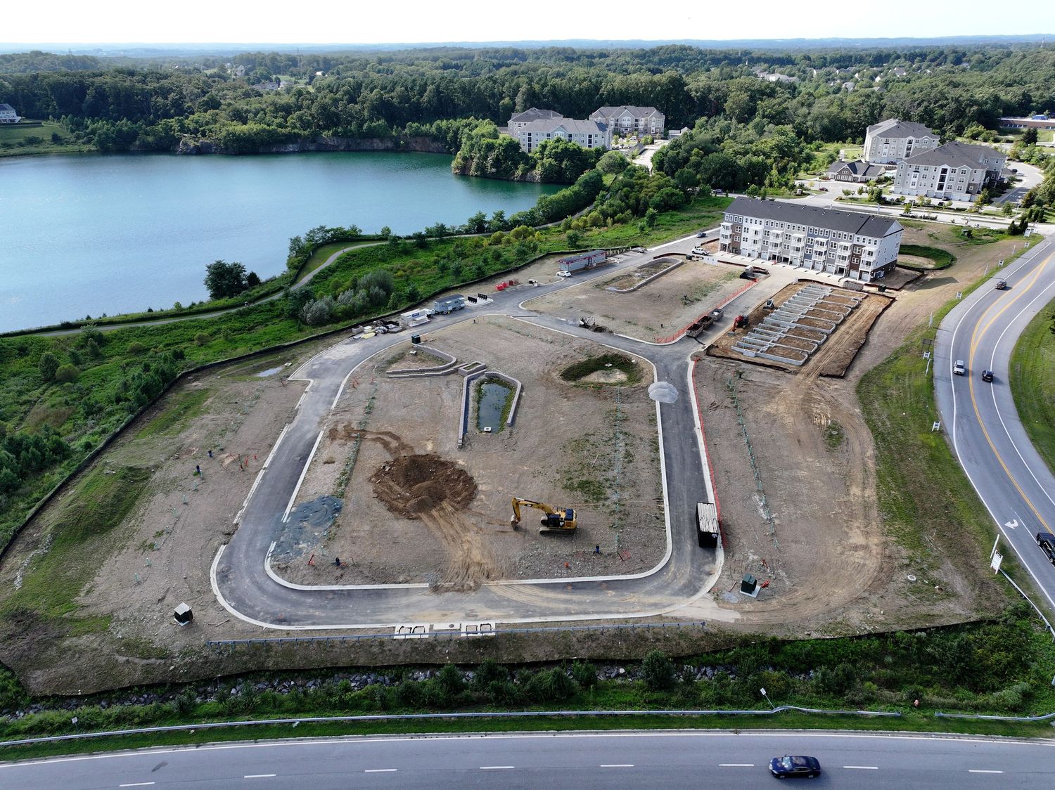Aerial view of a housing development with finished roads and ongoing building activity.