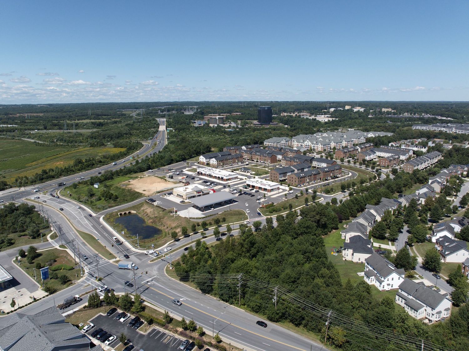 Wide aerial view of a suburban commercial area near major roads and intersections.