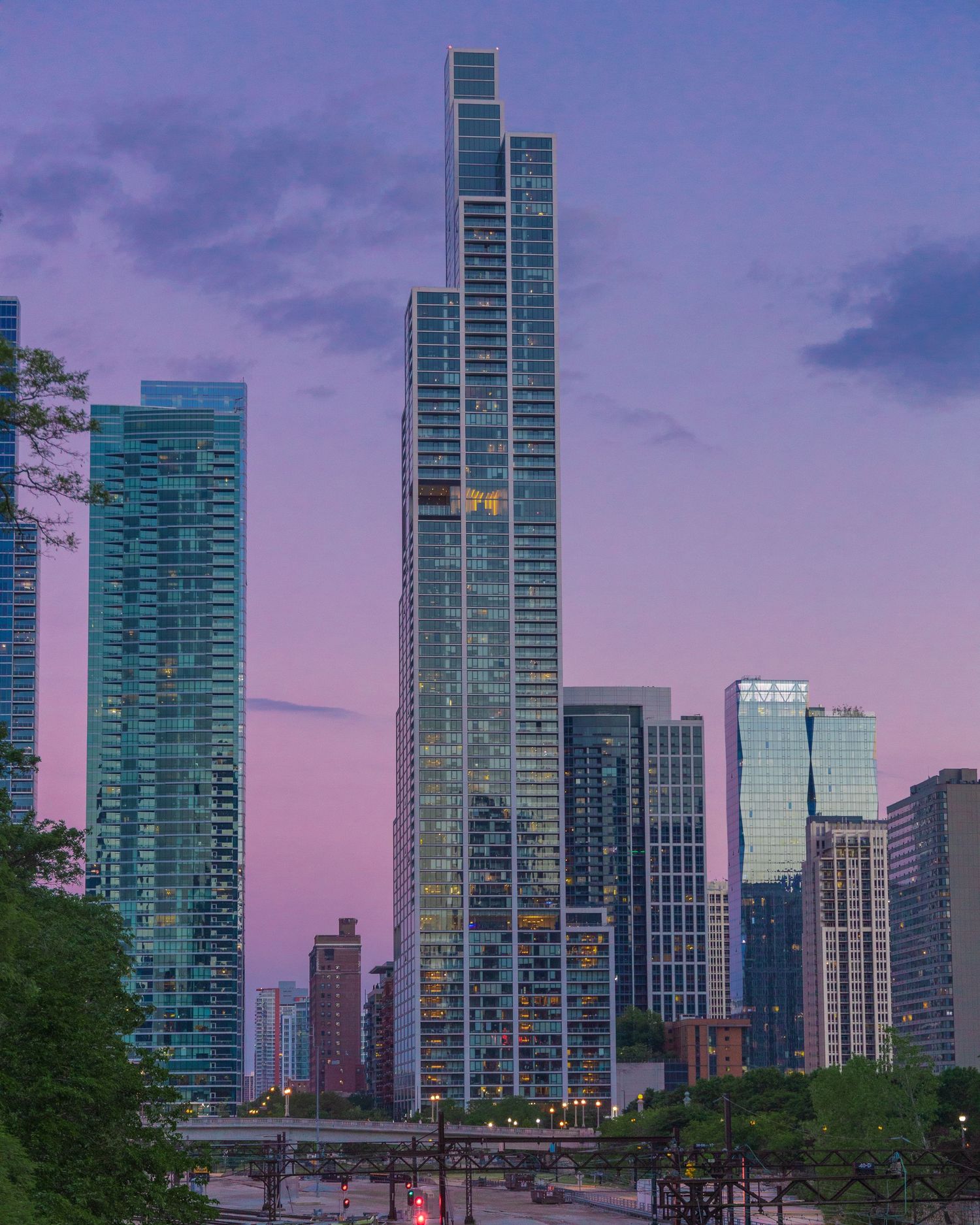 Vertical city skyline photo with modern high-rise buildings during blue hour.