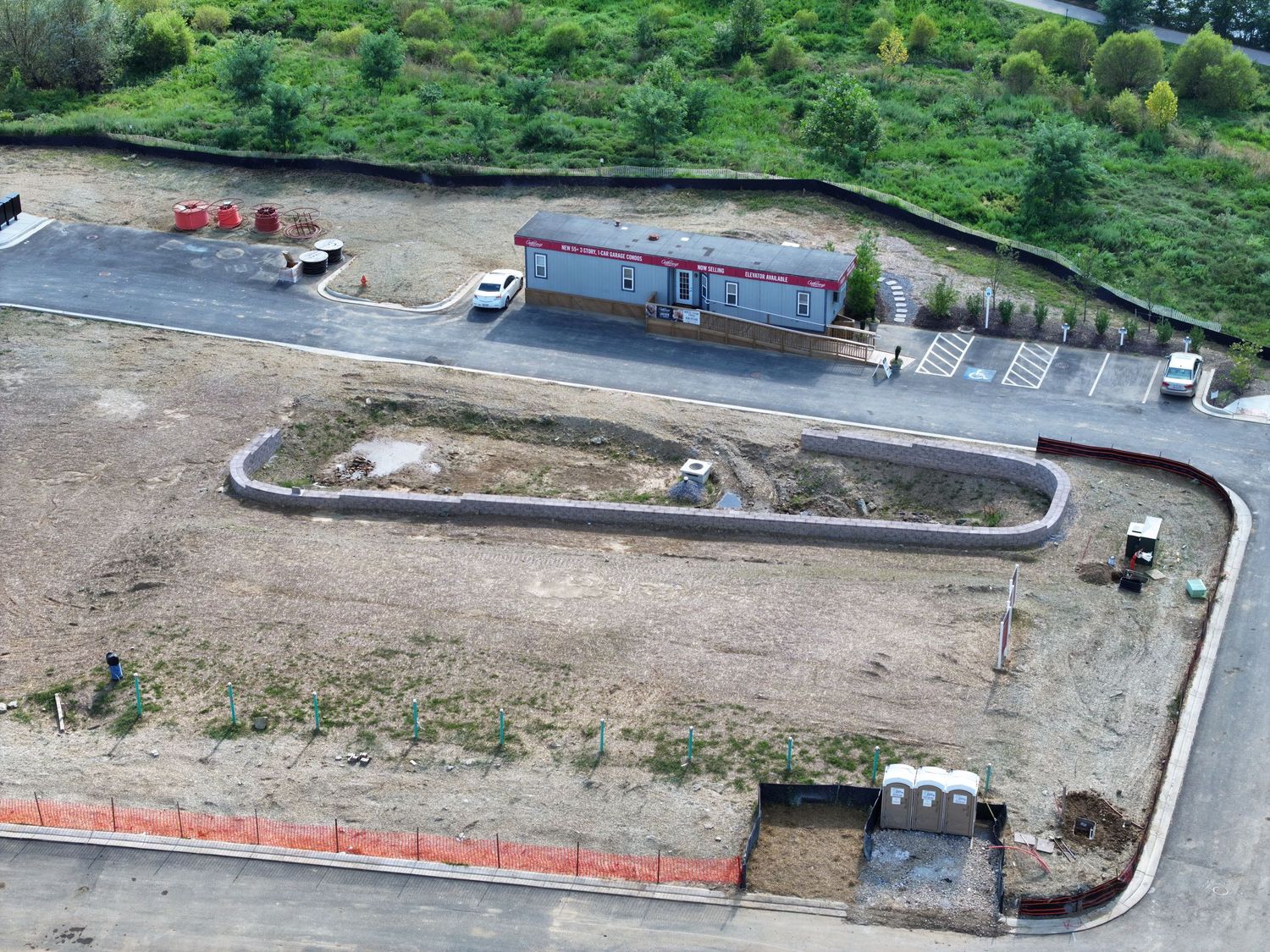 Aerial view of an active construction site with earthwork, foundations, and temporary access roads.