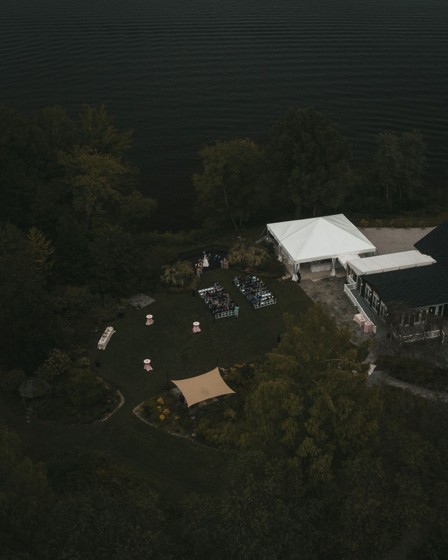 Aerial view of wedding guests seated during an outdoor ceremony.