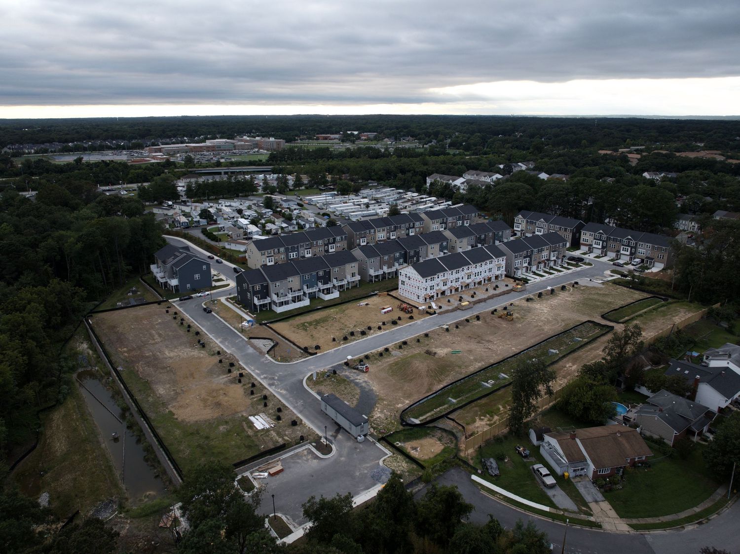 Aerial view of an active construction site with earthwork, foundations, and temporary access roads.