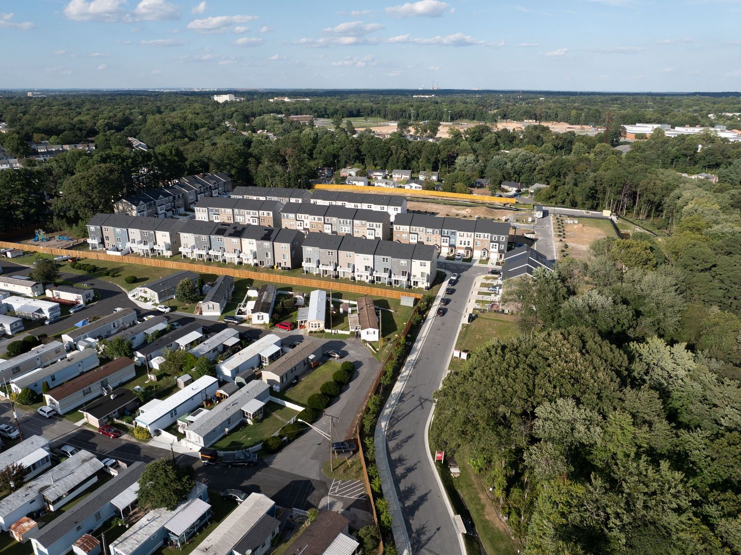 Aerial view of an active construction site with earthwork, foundations, and temporary access roads.