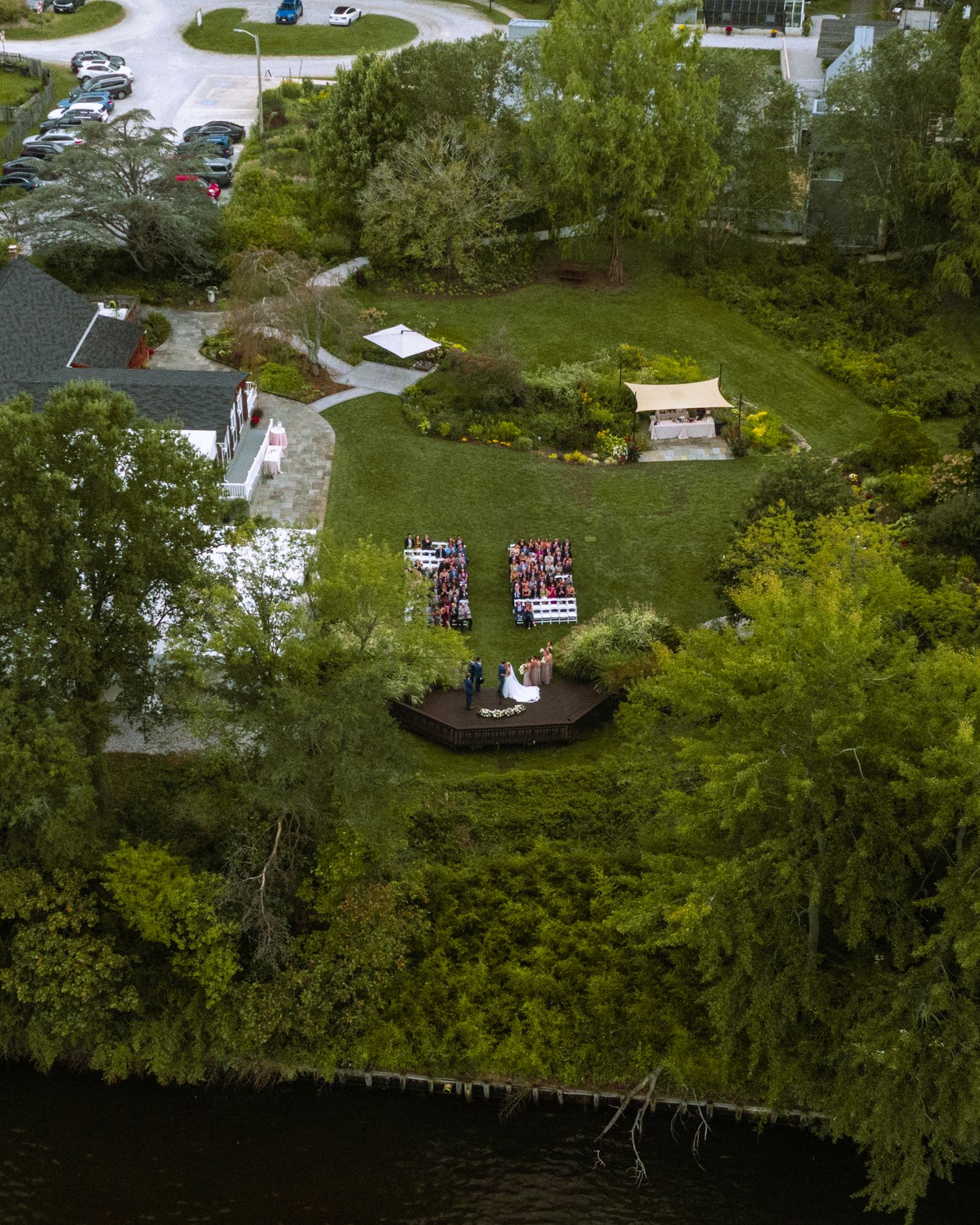 An aerial photograph at around 200' of a wedding ceremony, with the party watching the bride and groom at the alter during their ceremony.