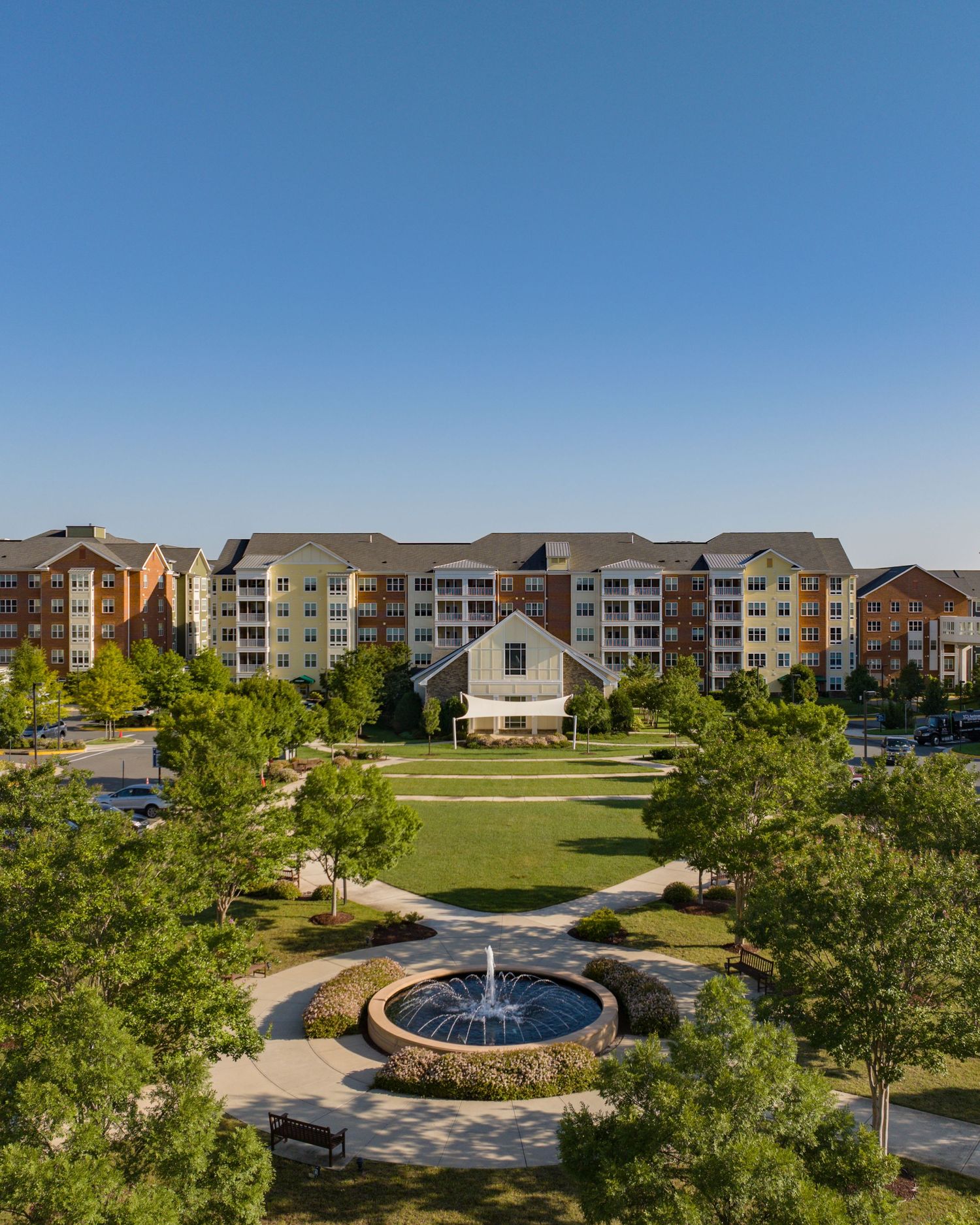 A Real Estate marketing image of an Erickson Senior Living Project showcasing the beautiful campus amenities of a water fountain and chapel.