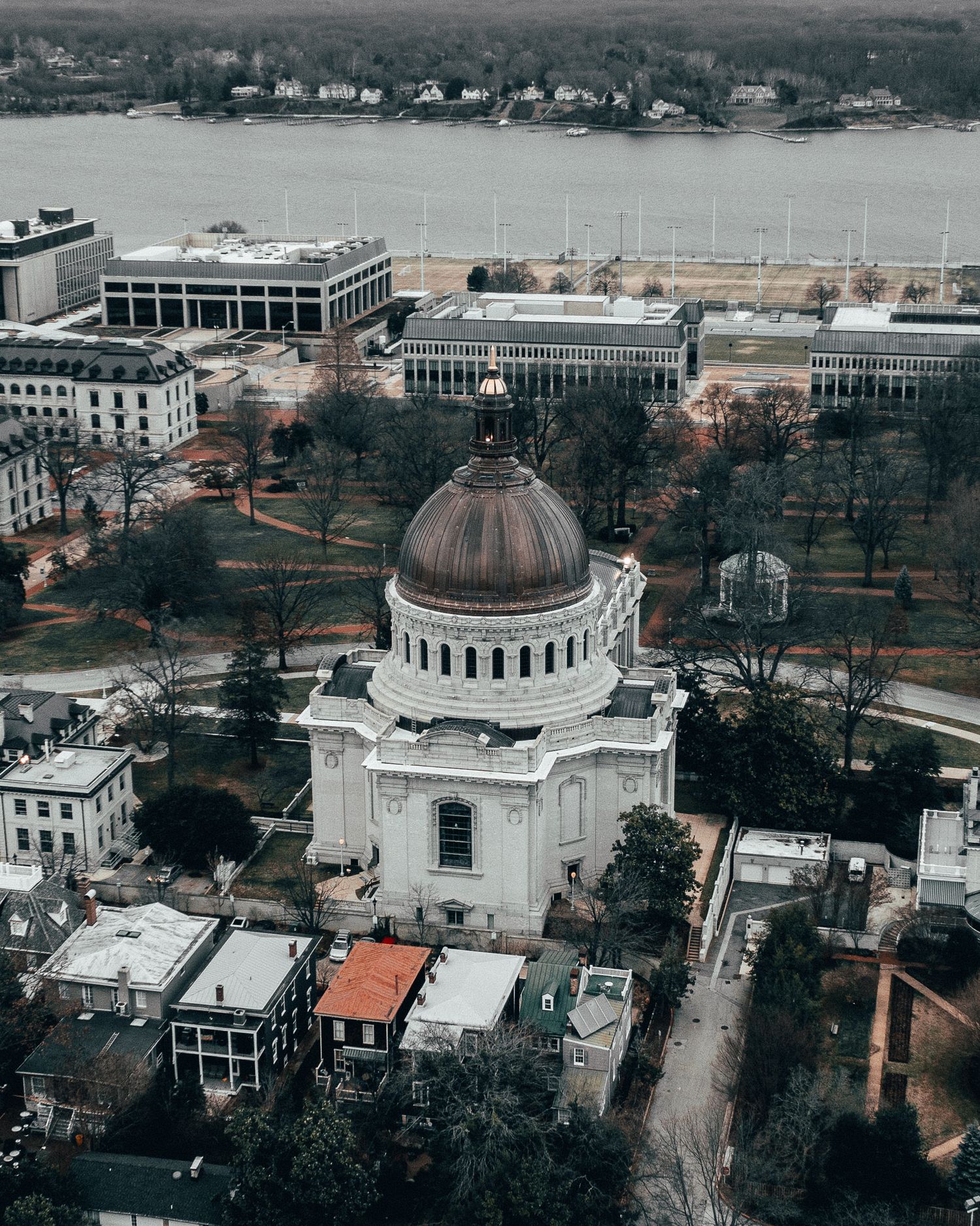 Aerial view of a domed Navy Chapel in Annapolis surrounded by dense urban development.