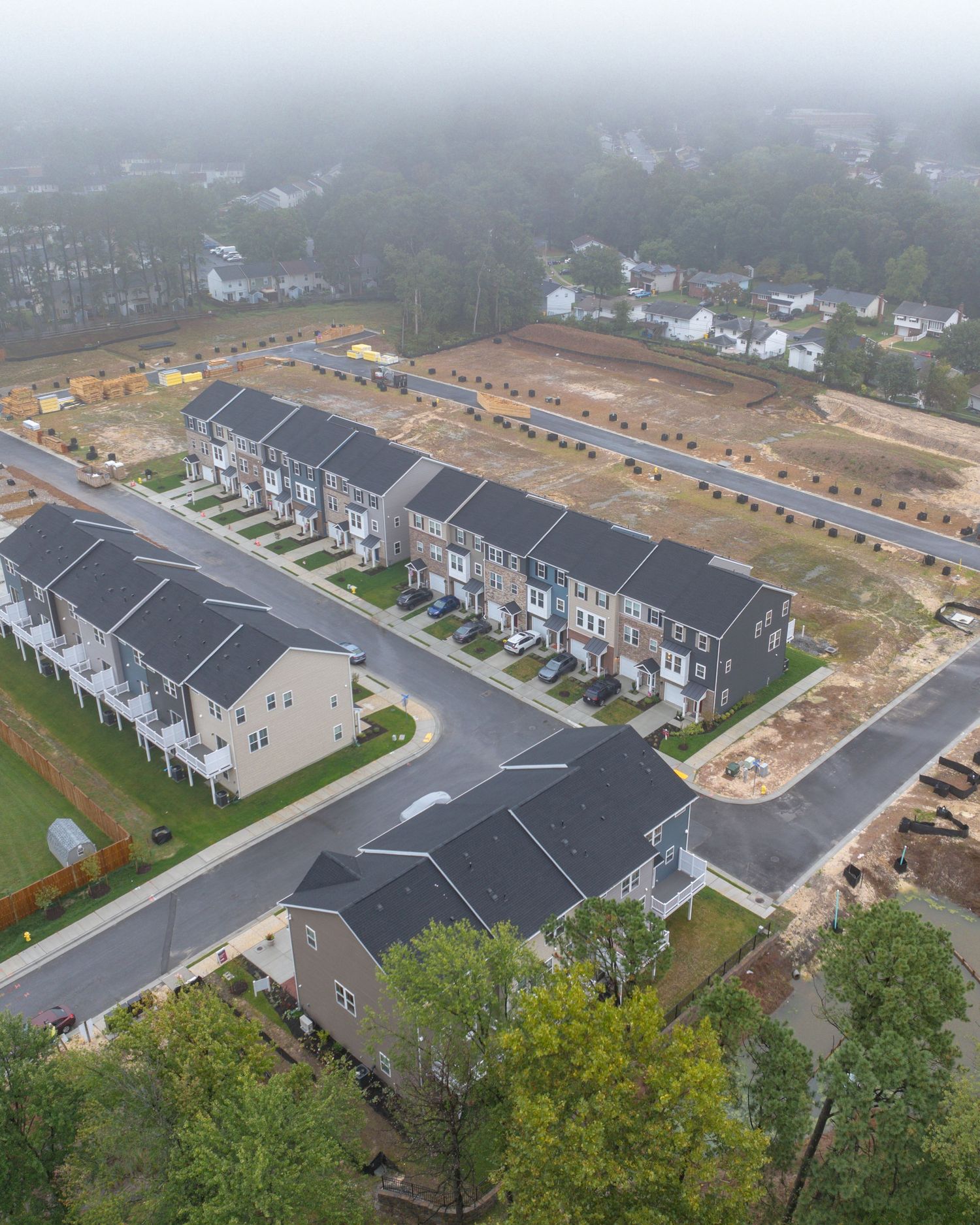 Aerial view of an active construction site with earthwork, foundations, and temporary access roads.