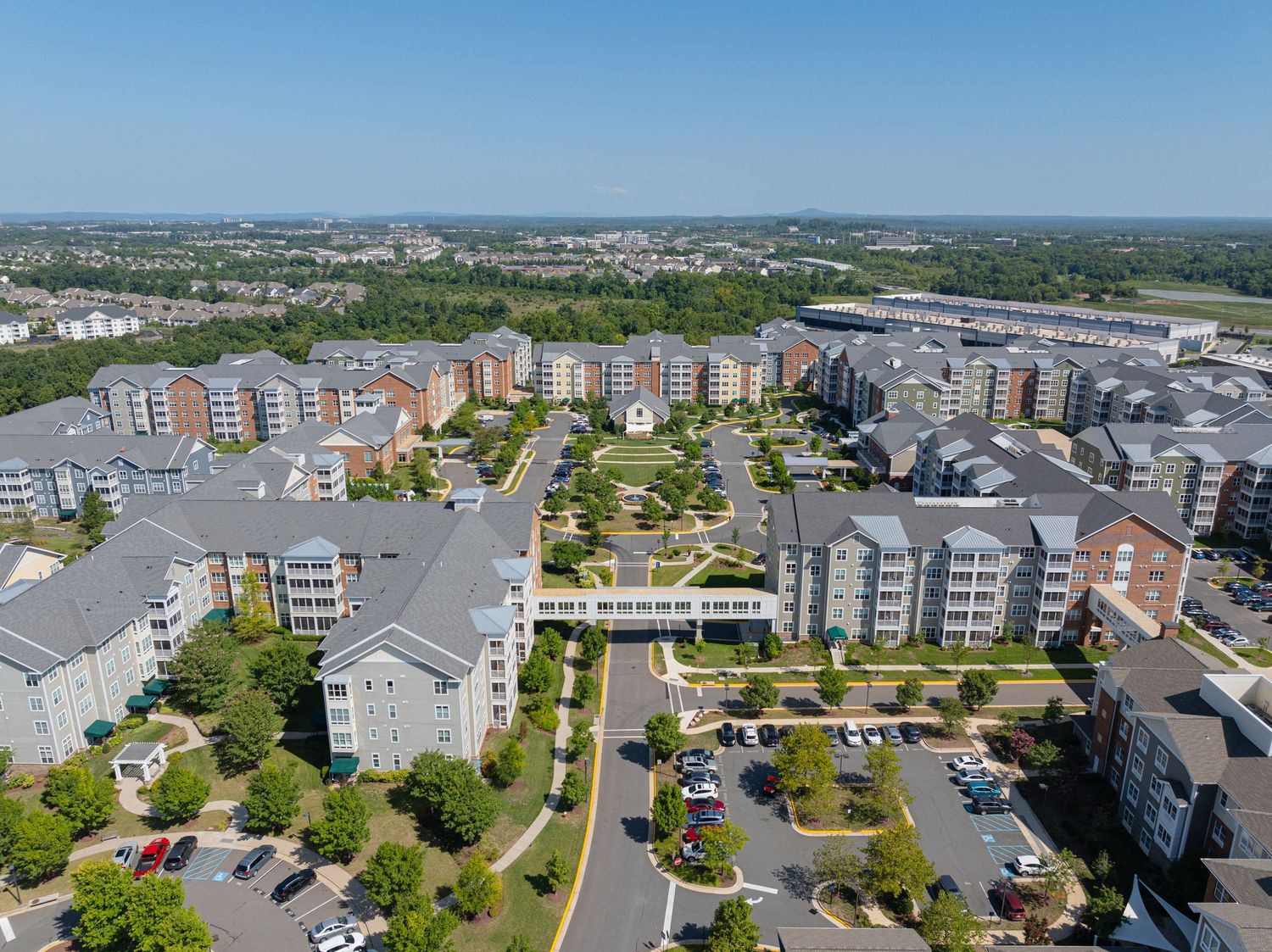 Aerial view of residential buildings and walking paths within a senior living community.