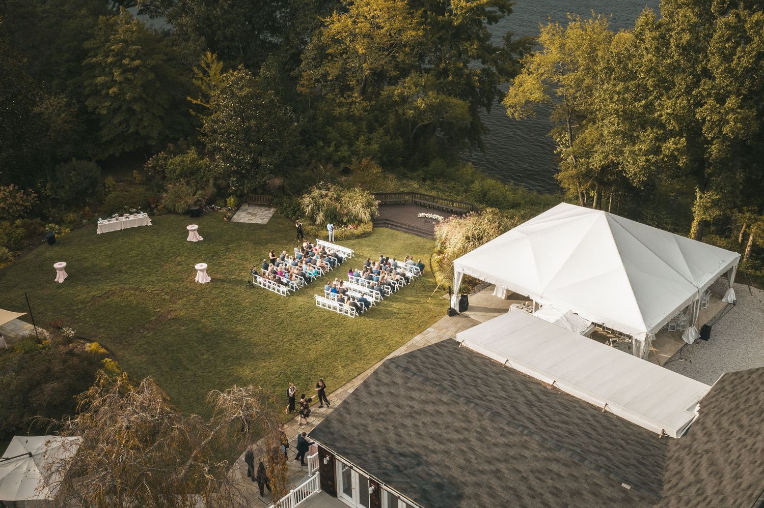 Aerial view of wedding guests seated during an outdoor ceremony.