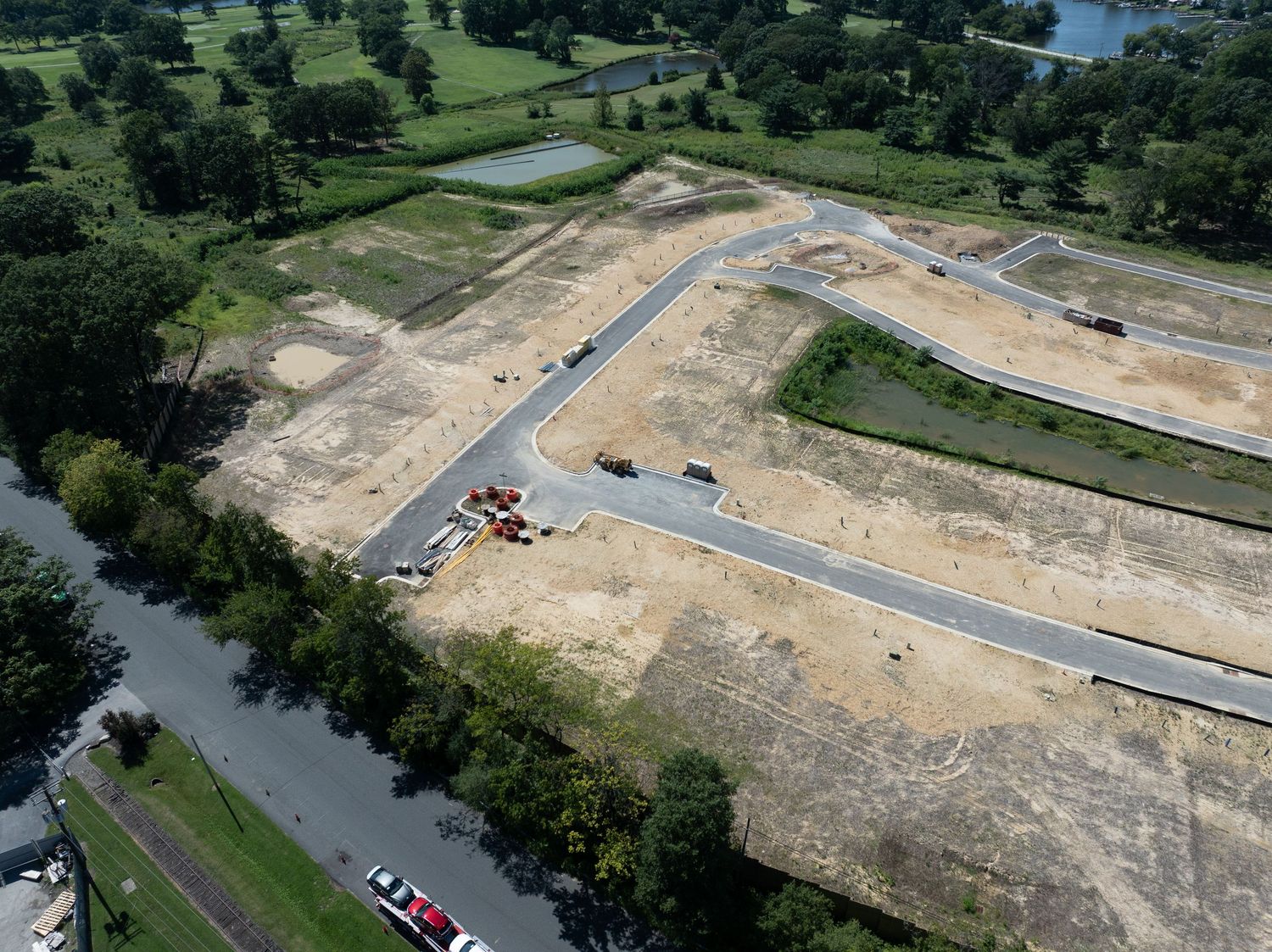 Drone photo showing early-stage construction with cleared land, grading, and nearby roadways.