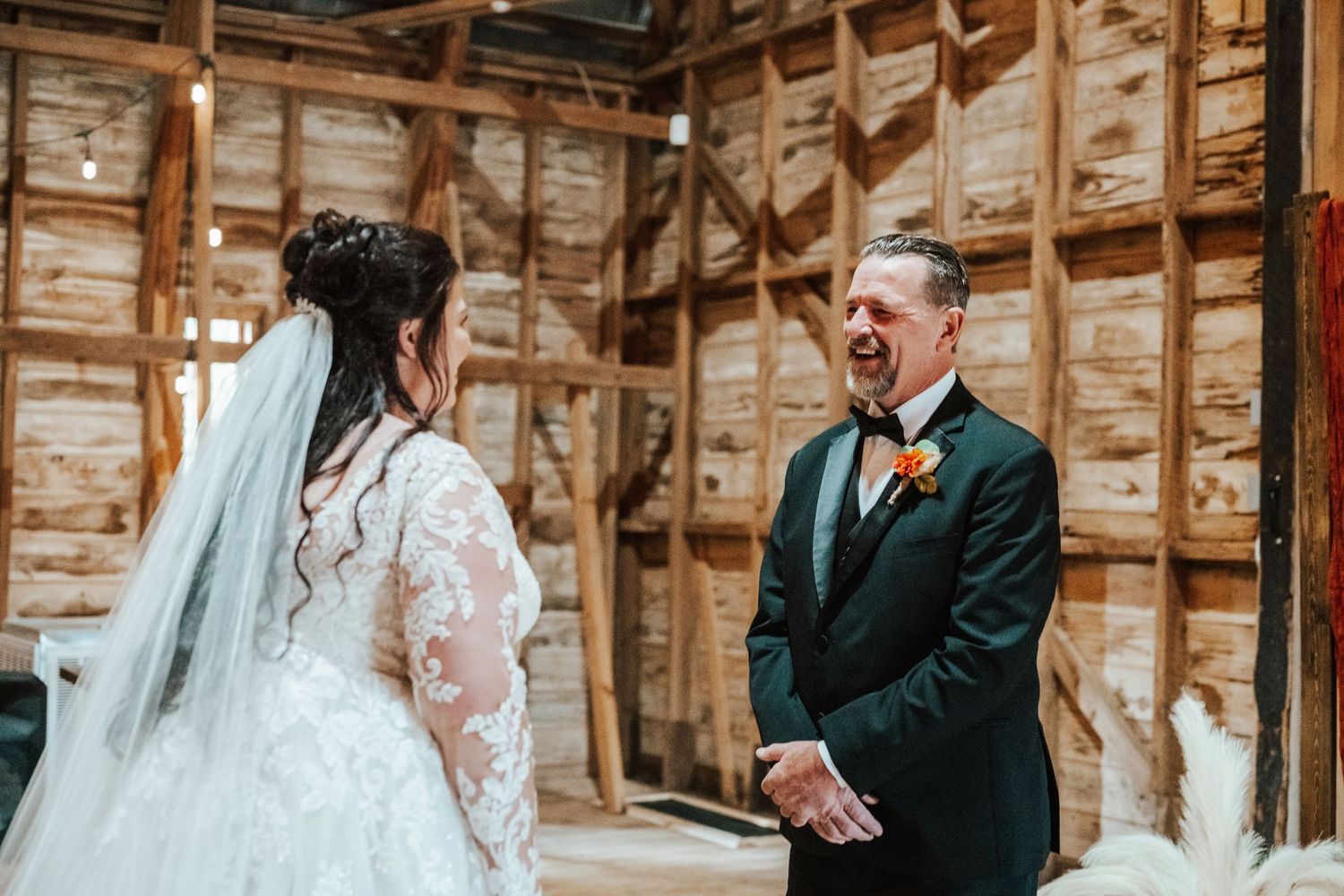 A rustic barn wedding ceremony features a first look and emotional moment with father and daughter.