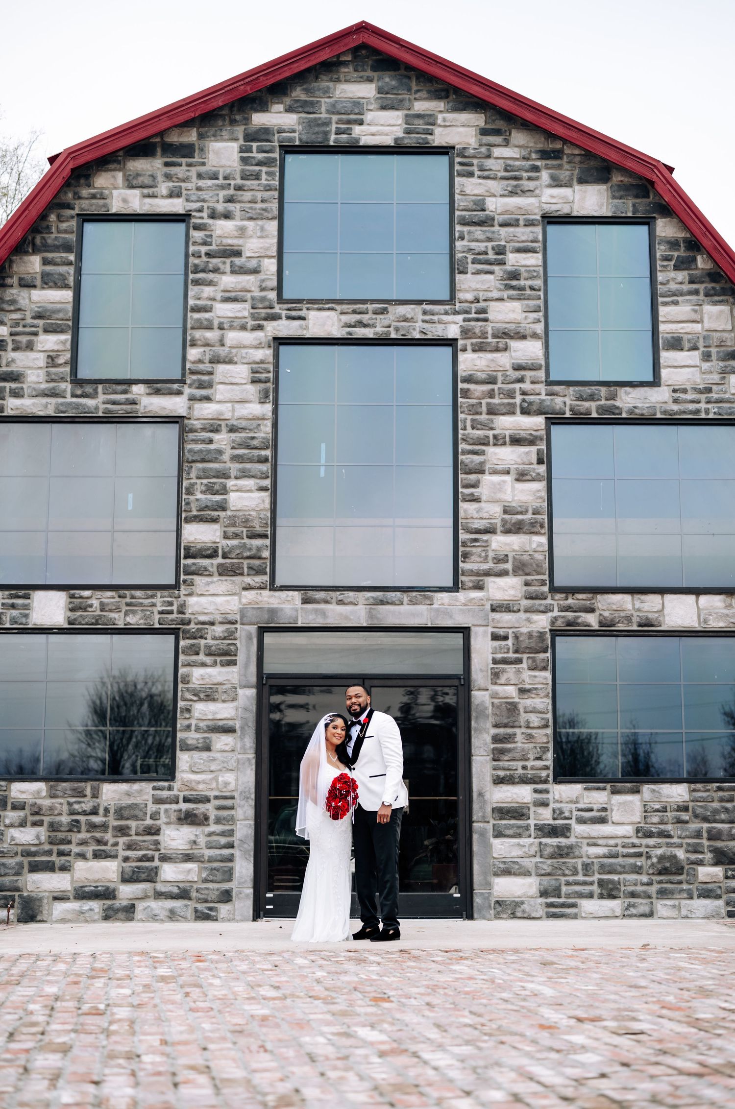 A series of architectural photos showing a modern stone building with large windows and red trim in a progressive sequence.
