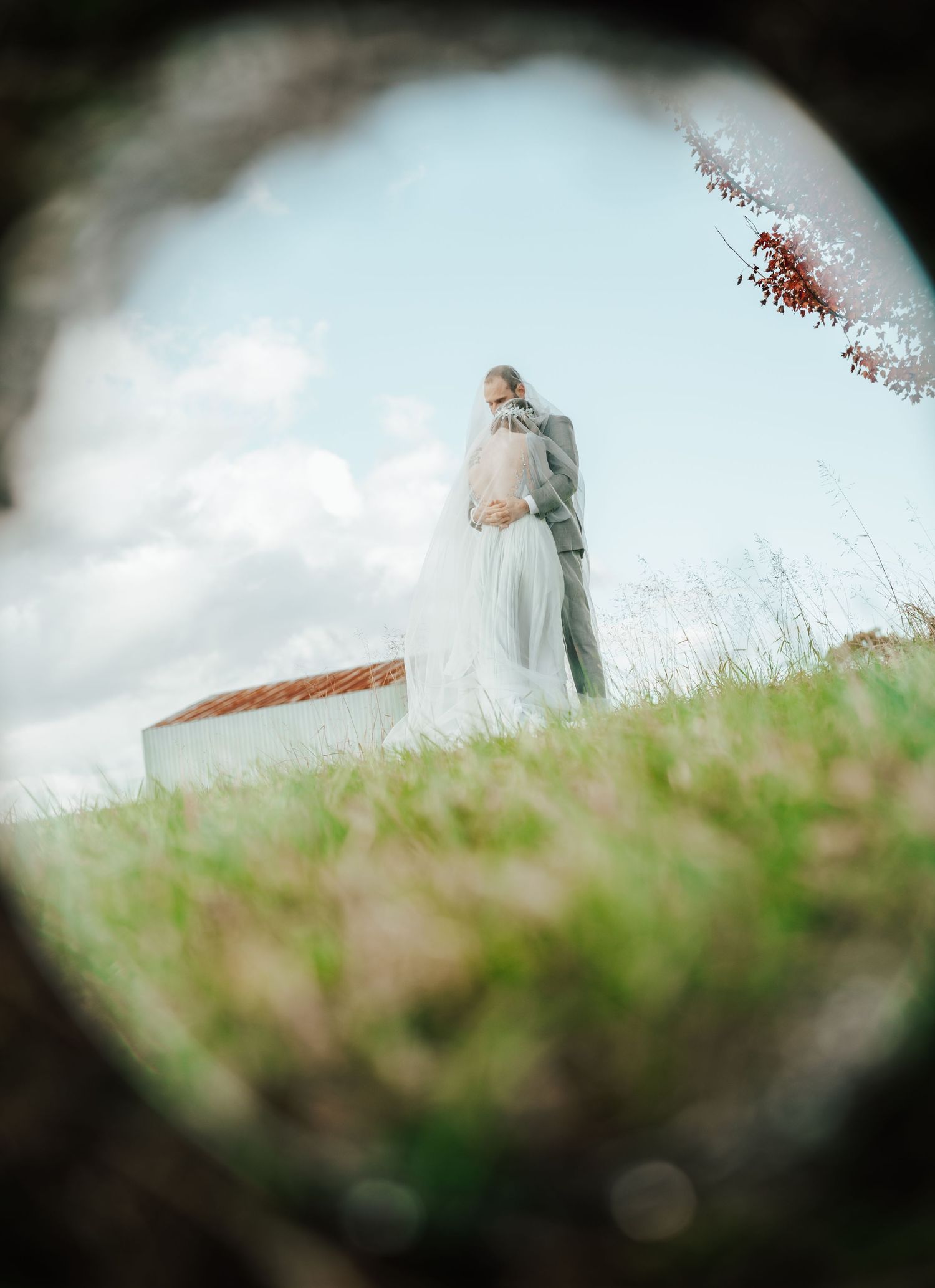 A dreamy sequence of soft-focus images showing bride and groom standing on a grassy hillside against a cloudy sky.