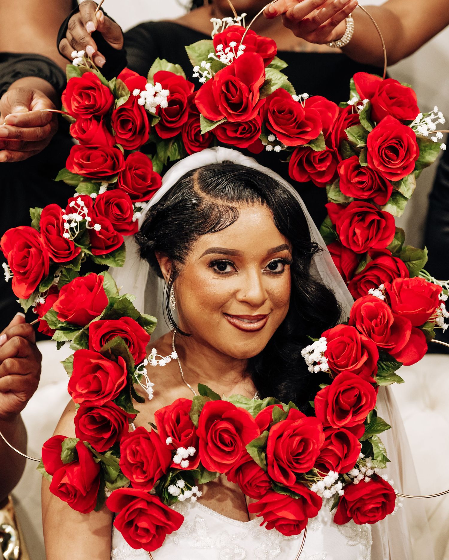 A stunning floral crown made of vibrant red roses and white baby's breath creates an elegant bridal accessory.