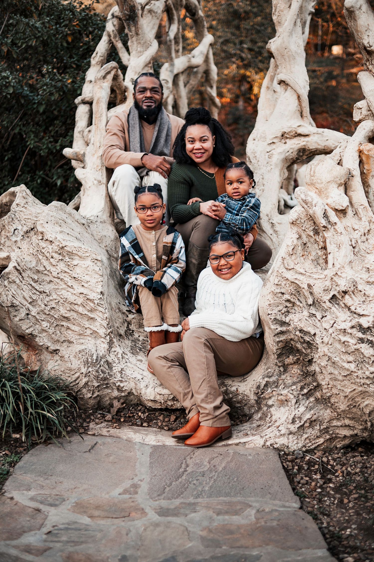 Family portrait session on natural stone formation with rustic outdoor backdrop.