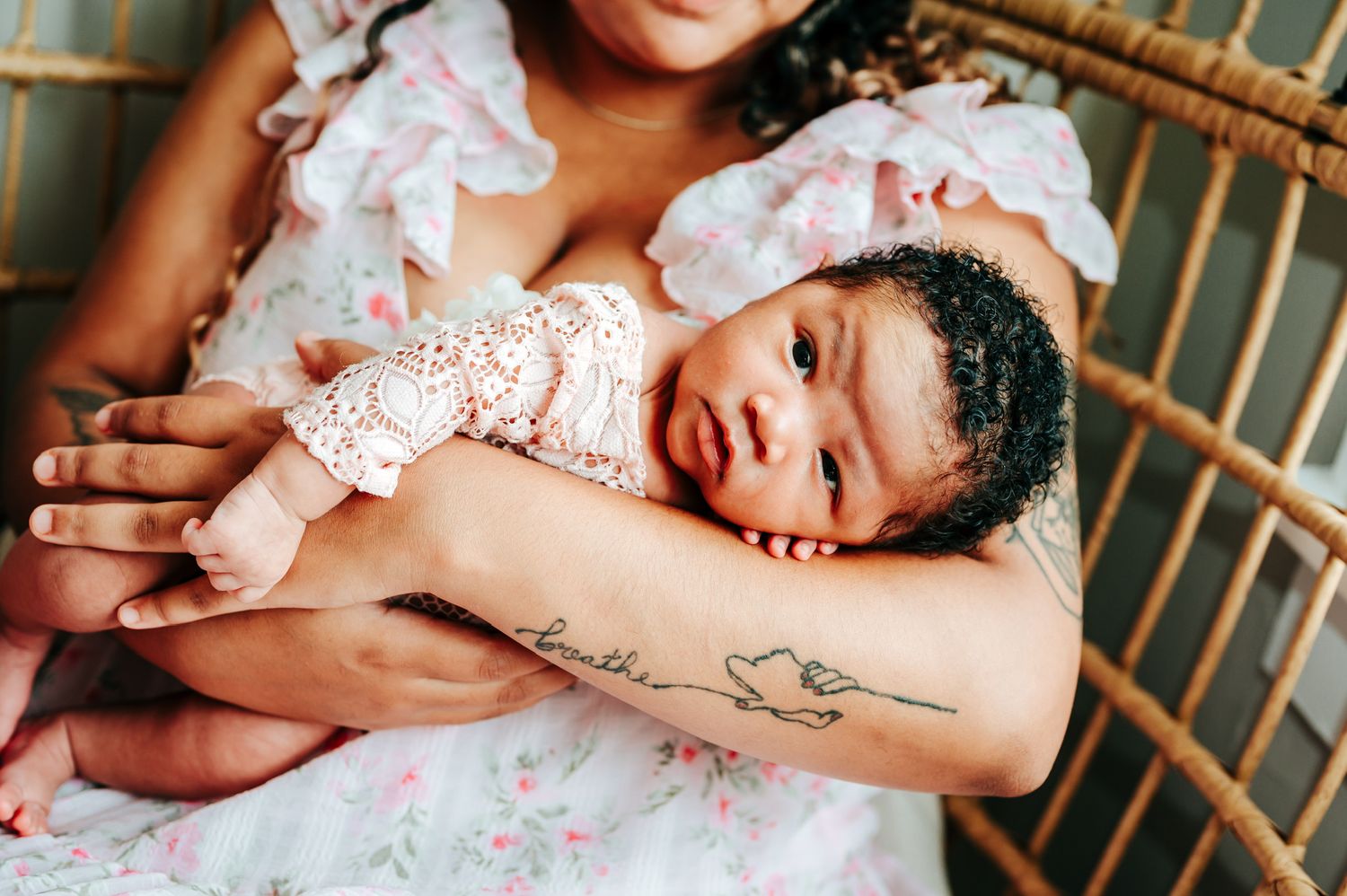 Sleeping baby in white lace outfit lying on wooden surface.
