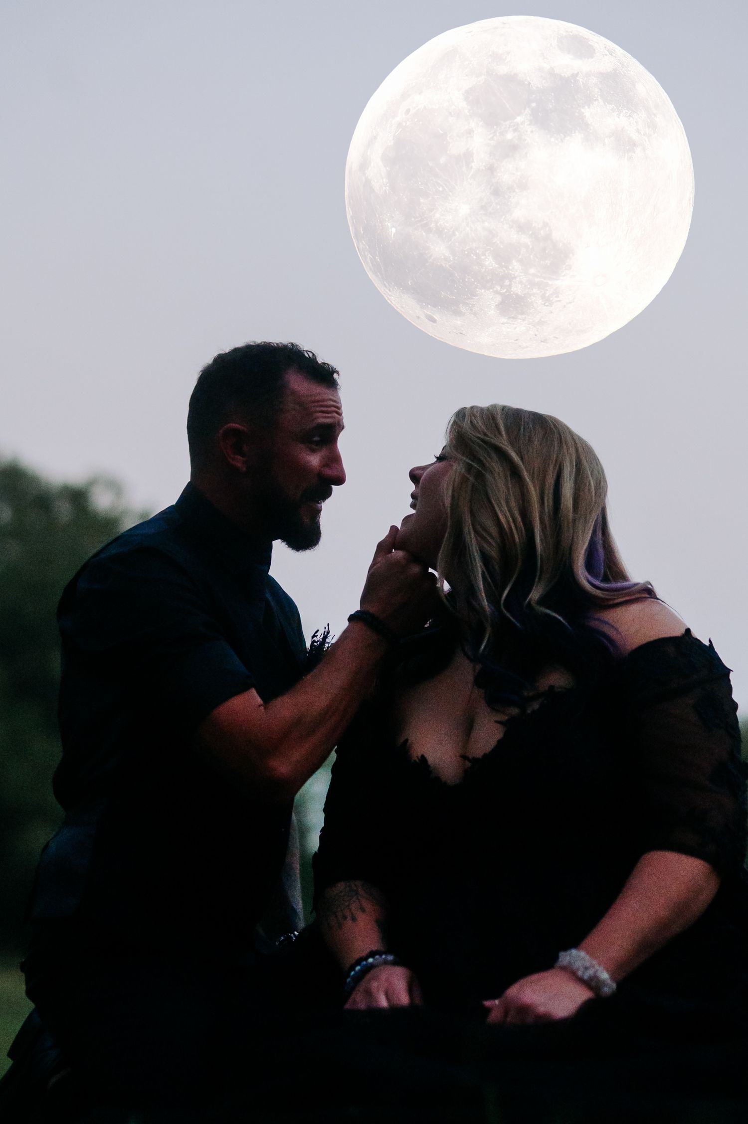 Silhouetted couple sharing romantic moments against a full moon backdrop.
