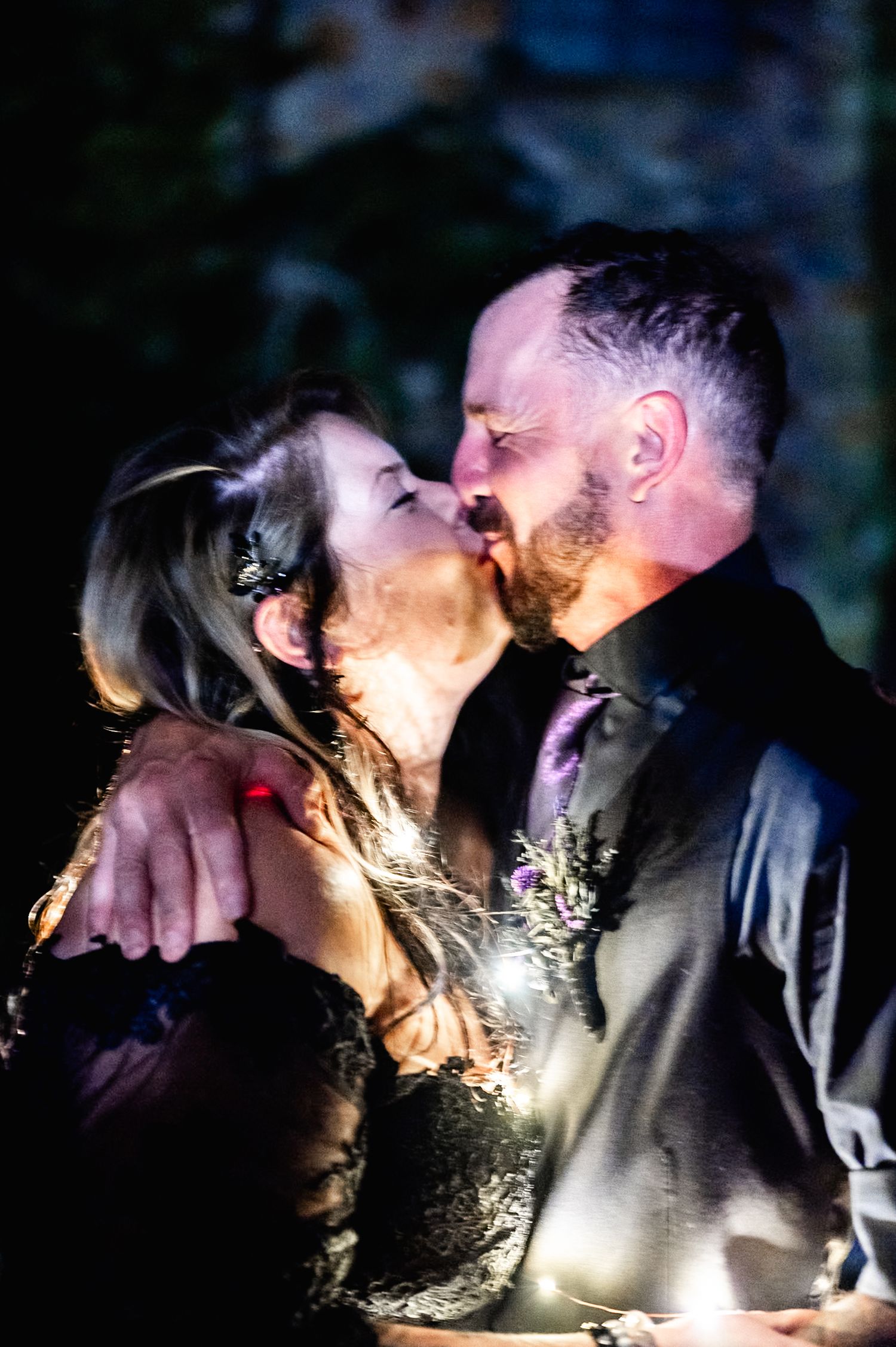Romantic couple illuminated by sparklers during nighttime photoshoot.
