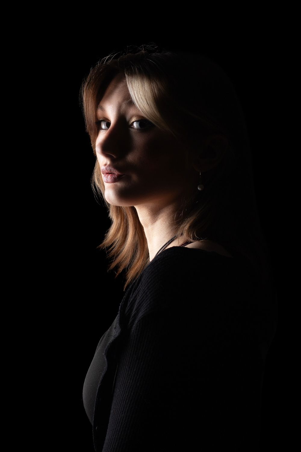 Dramatic portrait series in dark lighting showing profile angles with moody shadows and highlights.