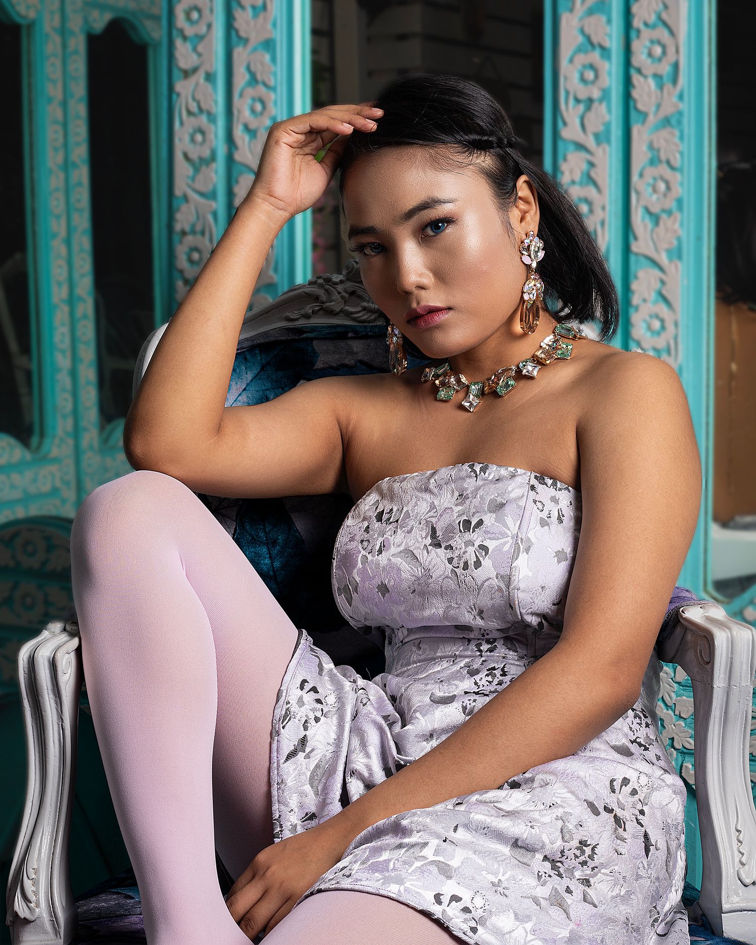 Fashion portraits in lavender dress against turquoise architectural backdrop.