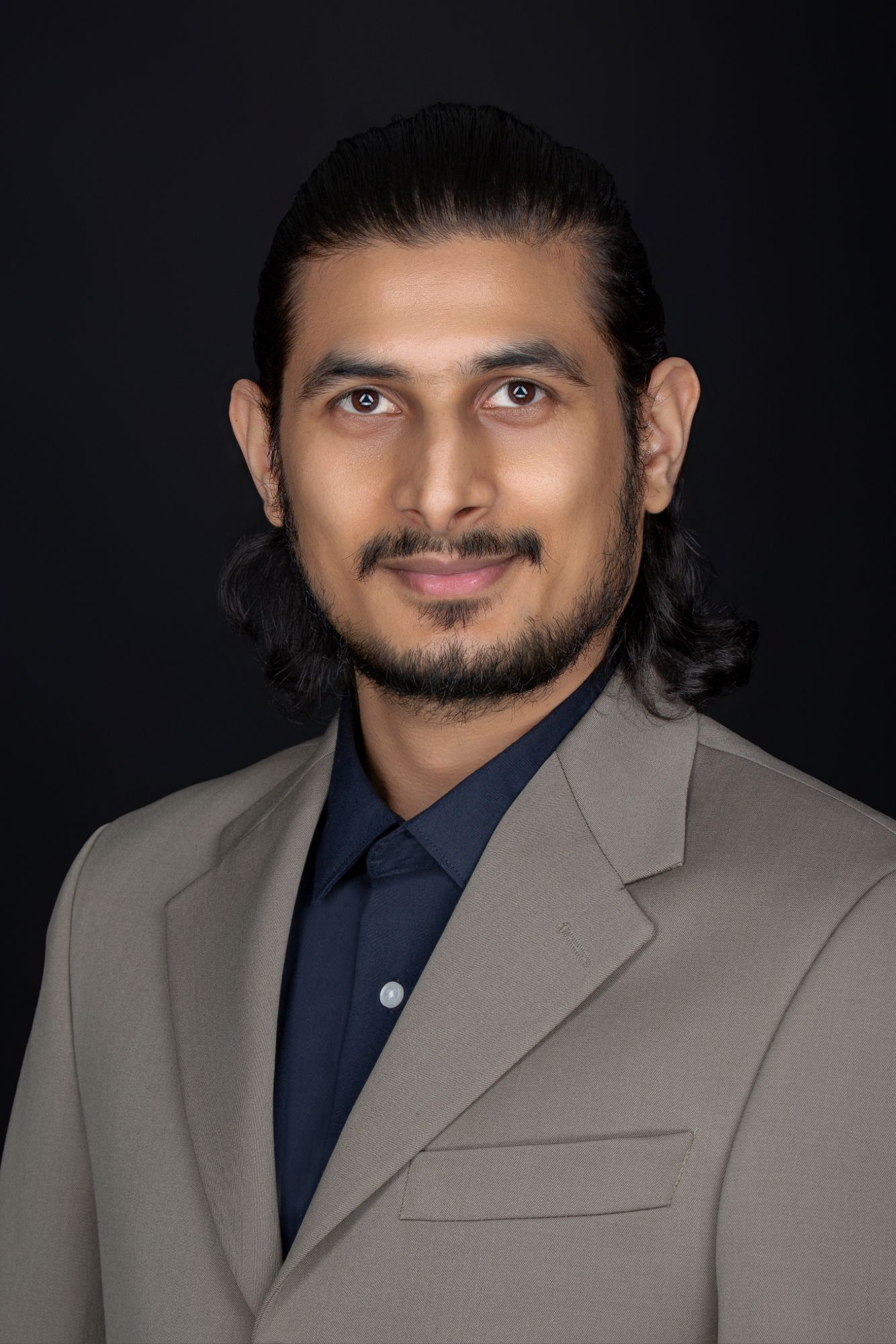 Studio portraits featuring person in light gray blazer and navy shirt against dark background.