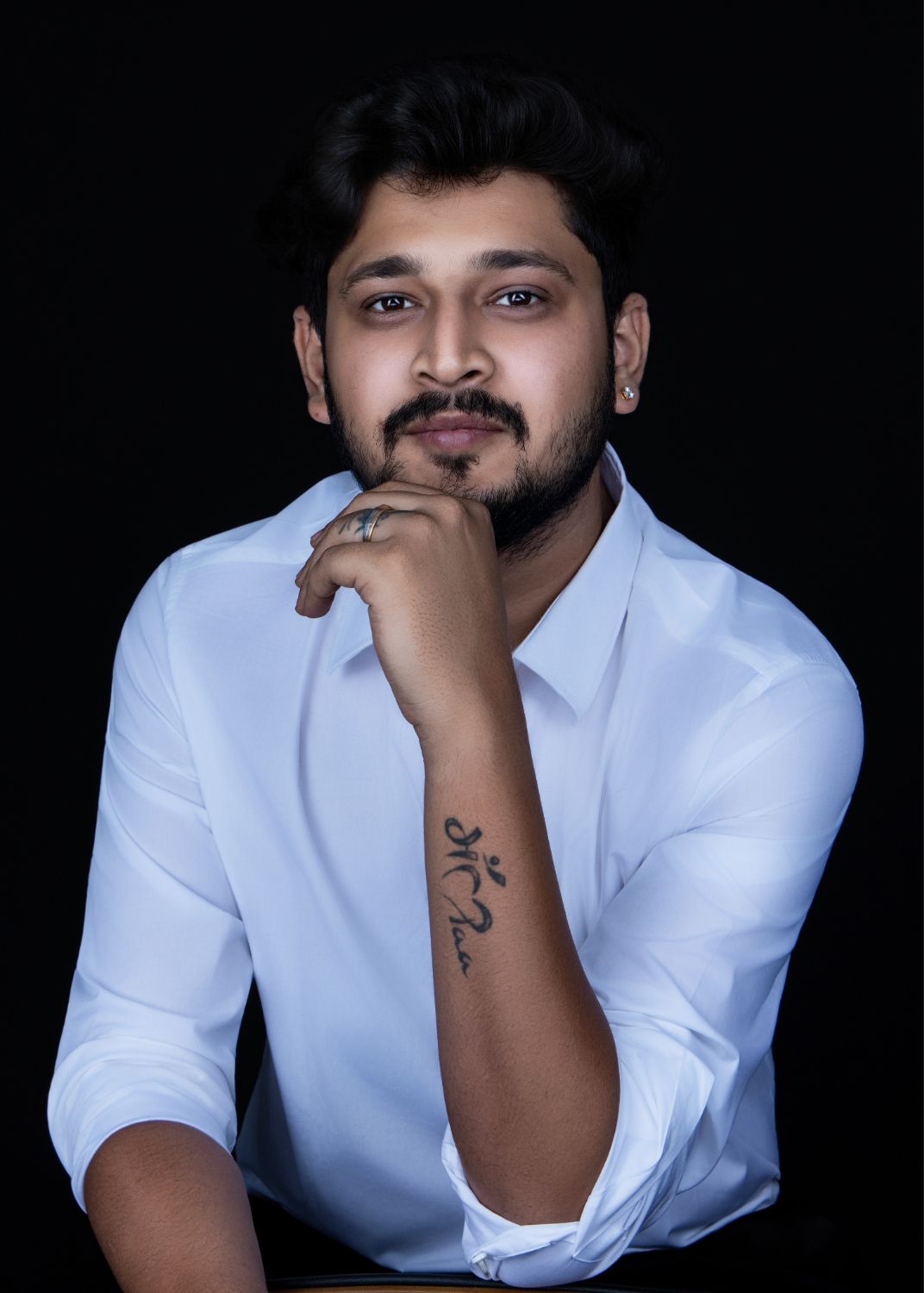 Person in white button-down shirt poses against dark background in artistic portrait series.