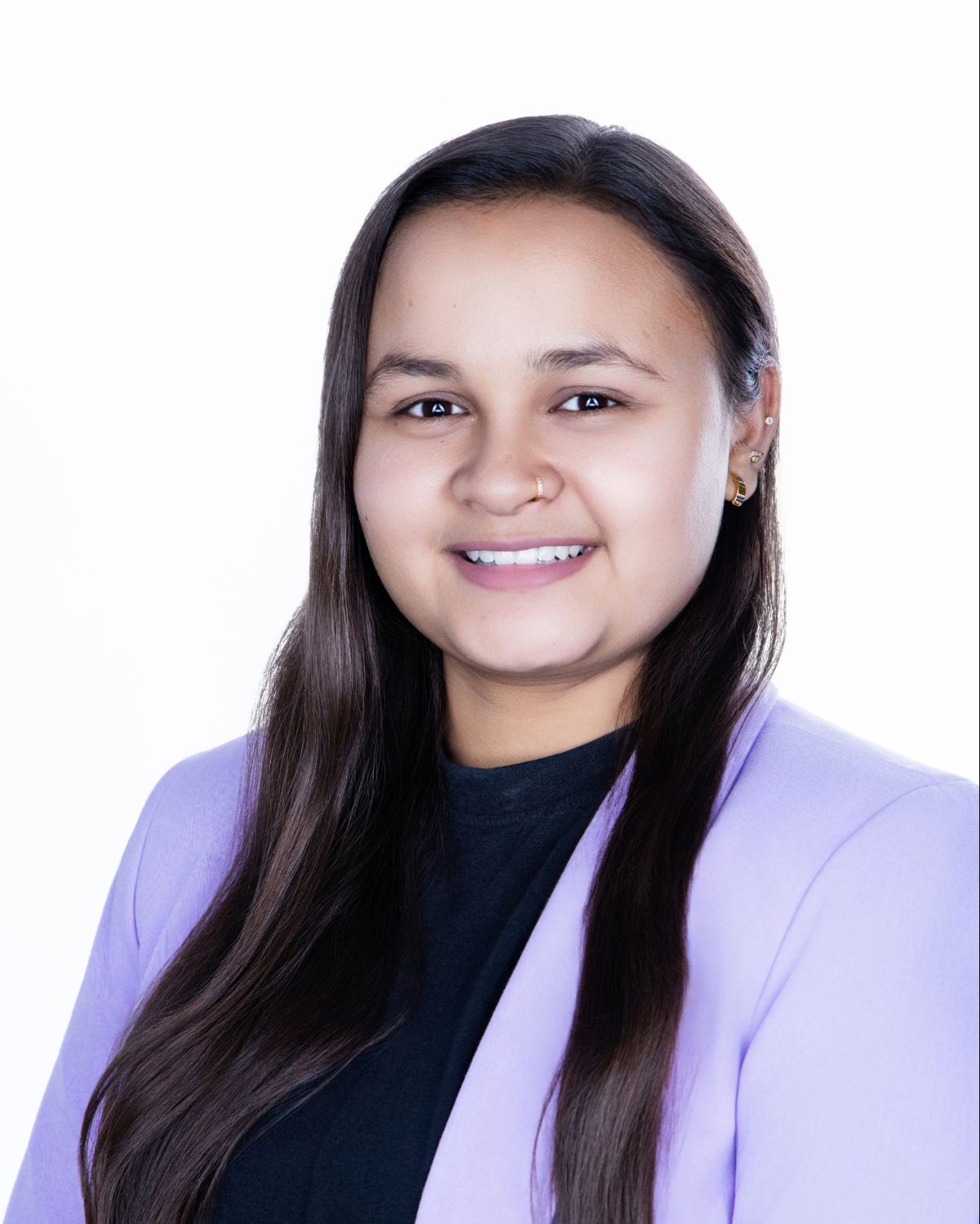 Young professional woman smiling in lavender blazer and black top against white background.