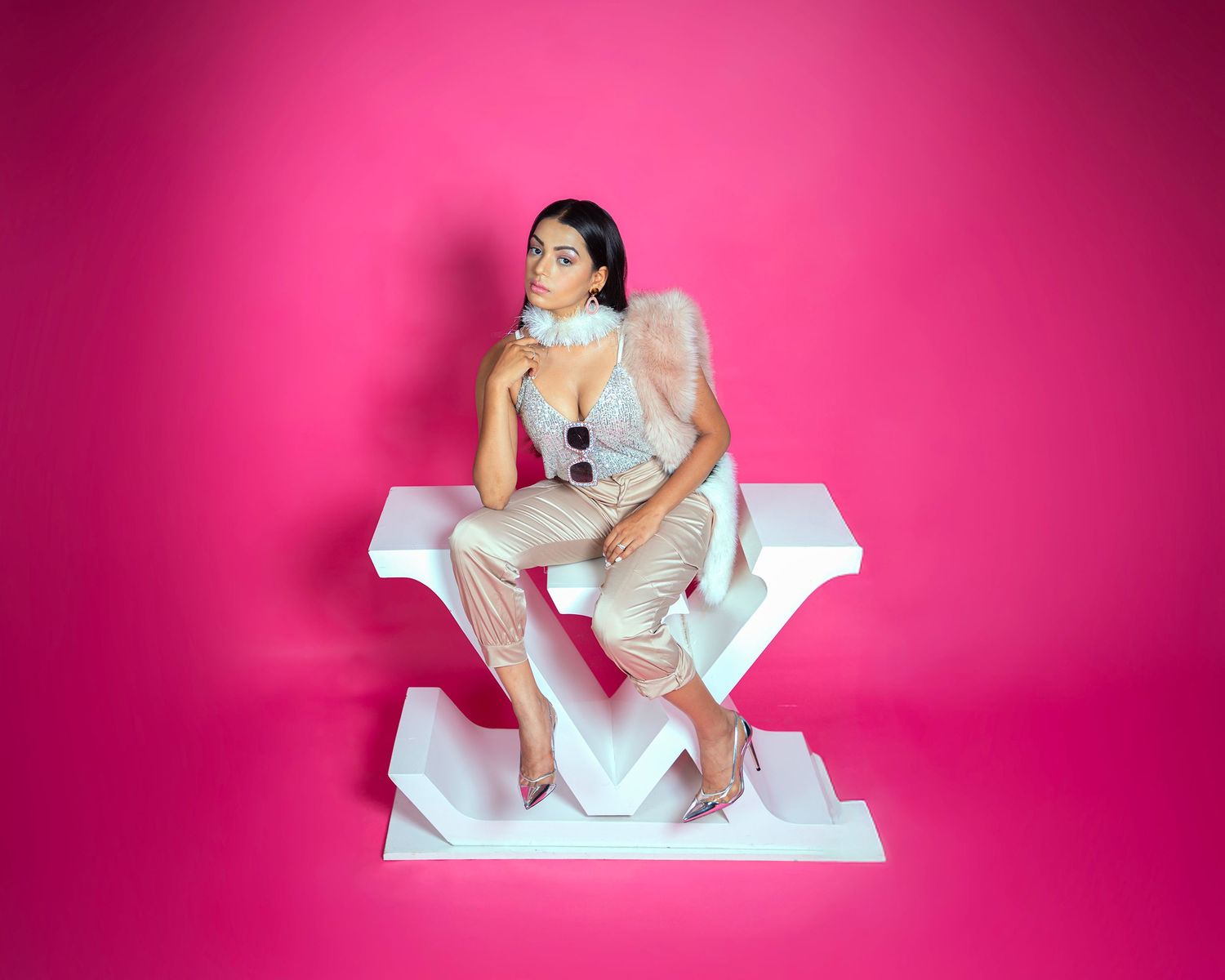 Artistic photo series of model in white outfit against bright pink backdrop.