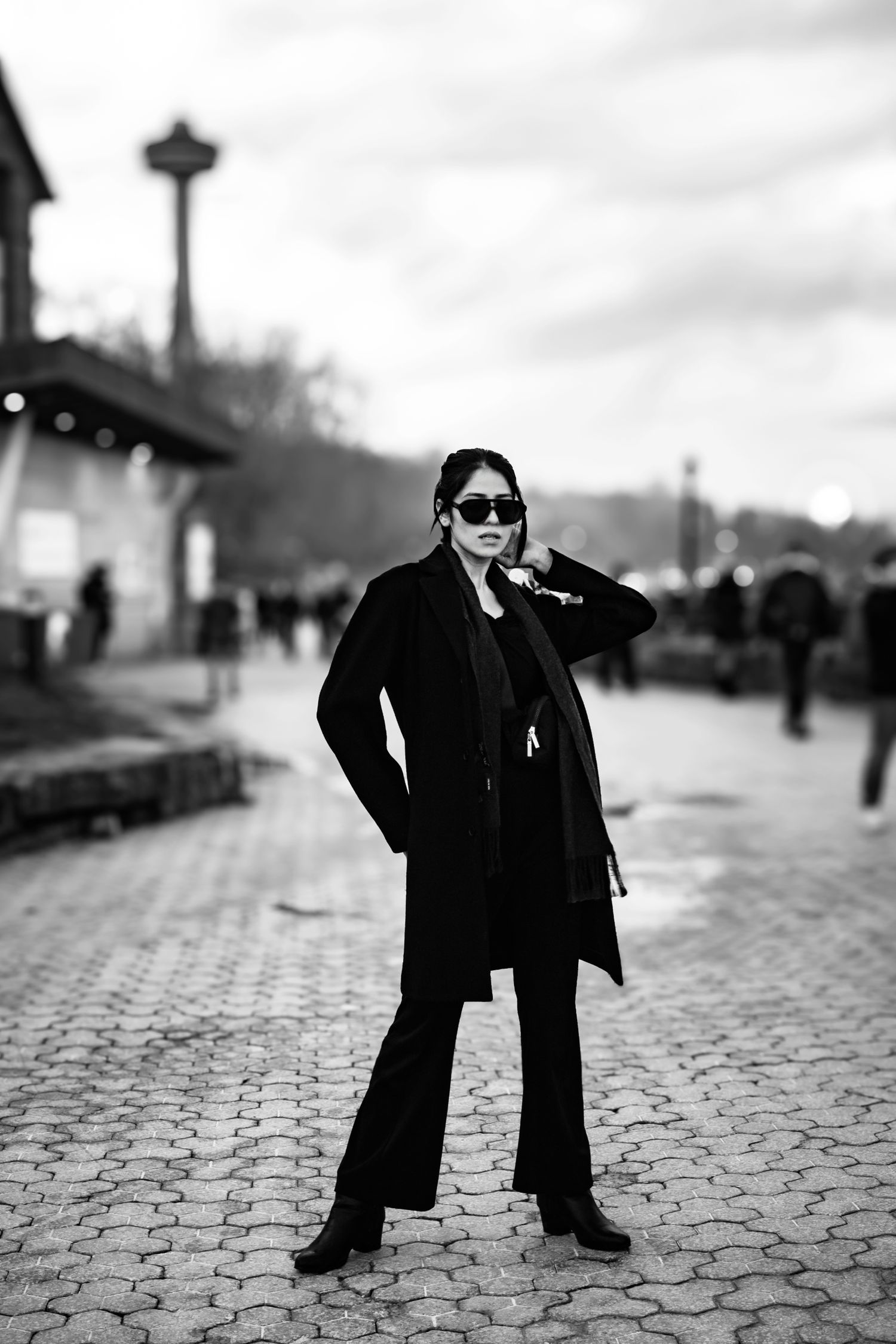 Artistic black and white photo sequence showing a figure in dark coat and sunglasses on cobblestone street.