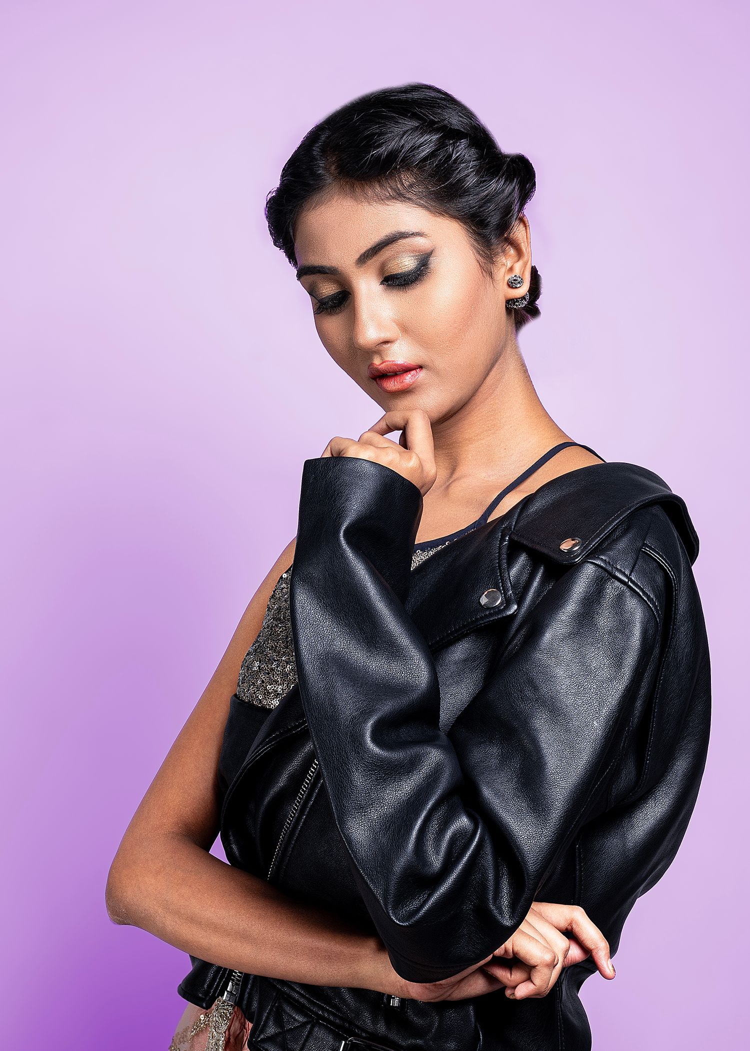 Fashion portraits in black leather outfit against purple background.
