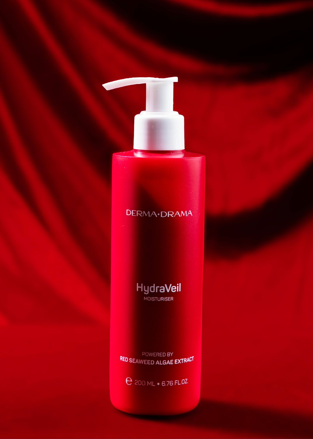 Red cosmetic bottles displayed on a luxurious red velvet background showcasing elegant skincare packaging design.