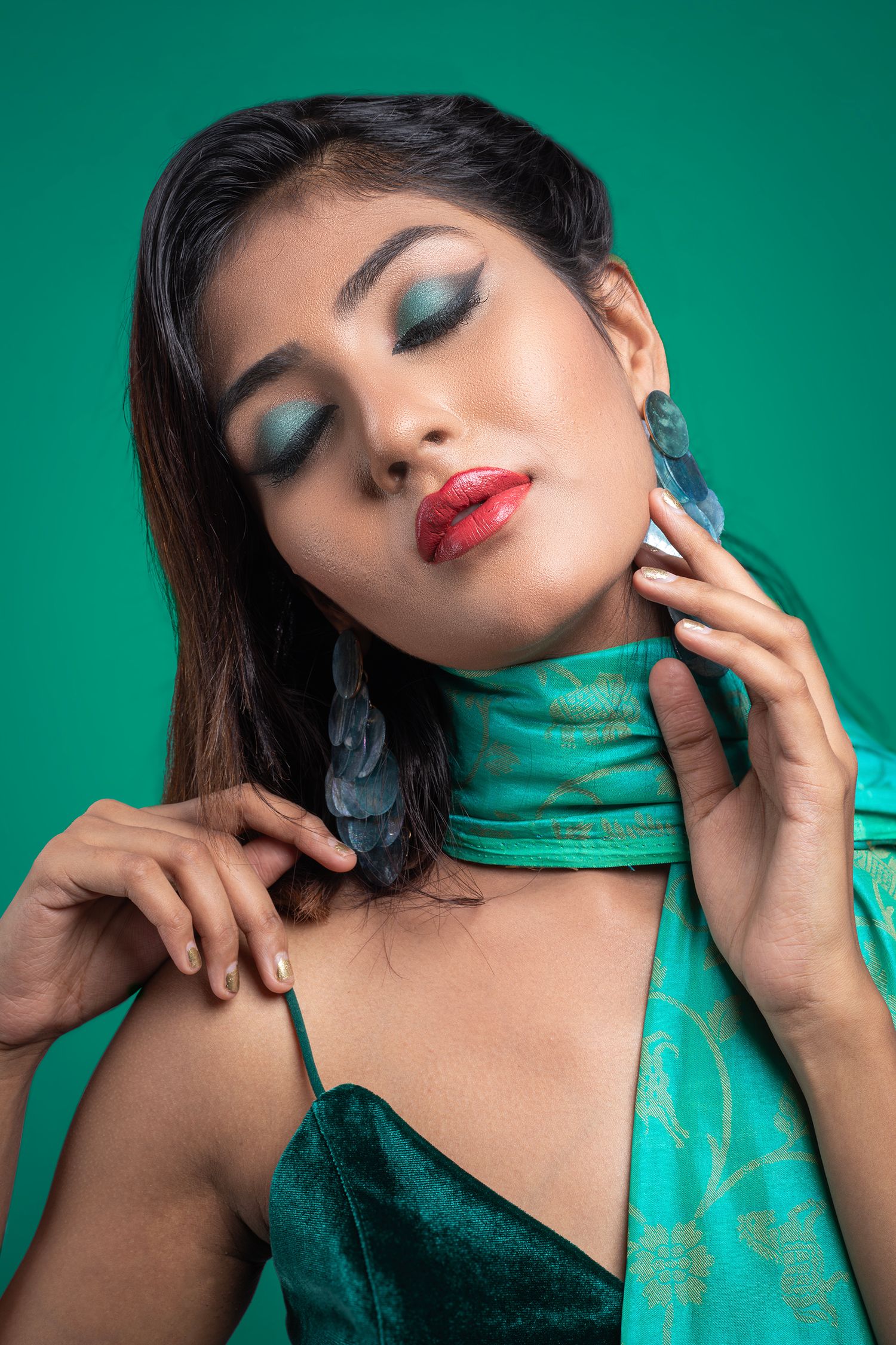 Fashion beauty shots featuring turquoise makeup and styling against emerald green background.