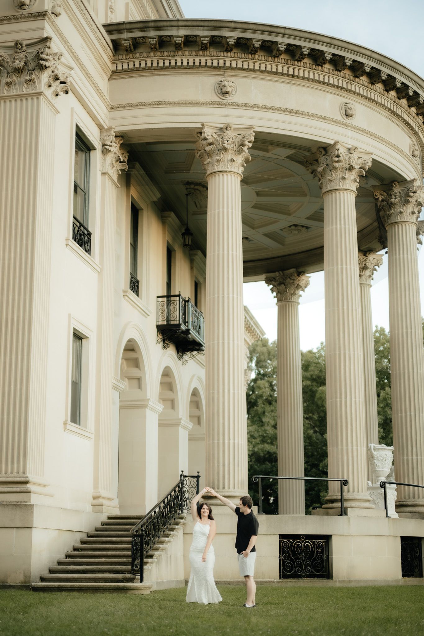 Couple dancing in front of a grand neoclassical building with tall Corinthian columns and arched portico.