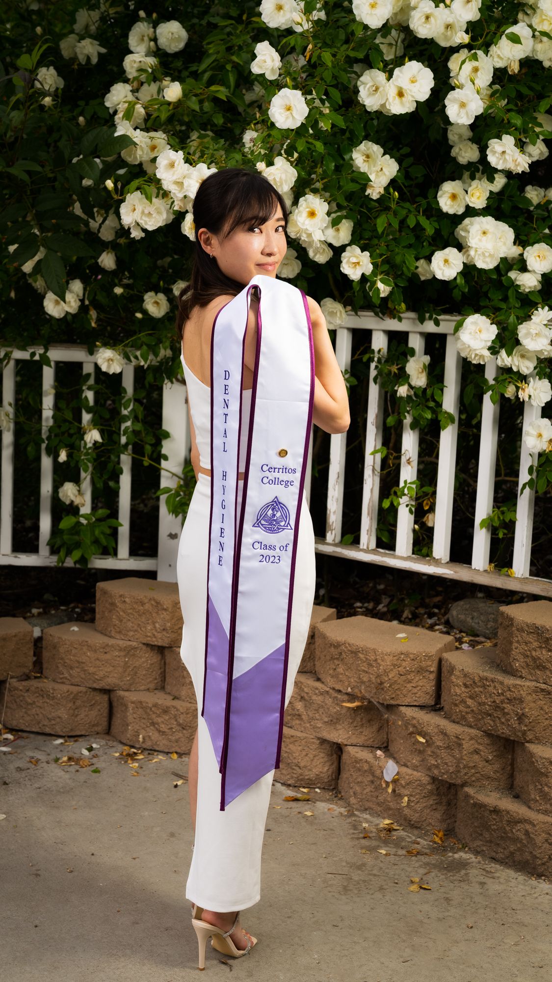 A series of photos showing a white graduation  for a dental hygienist with purple accents against a backdrop of white roses.
