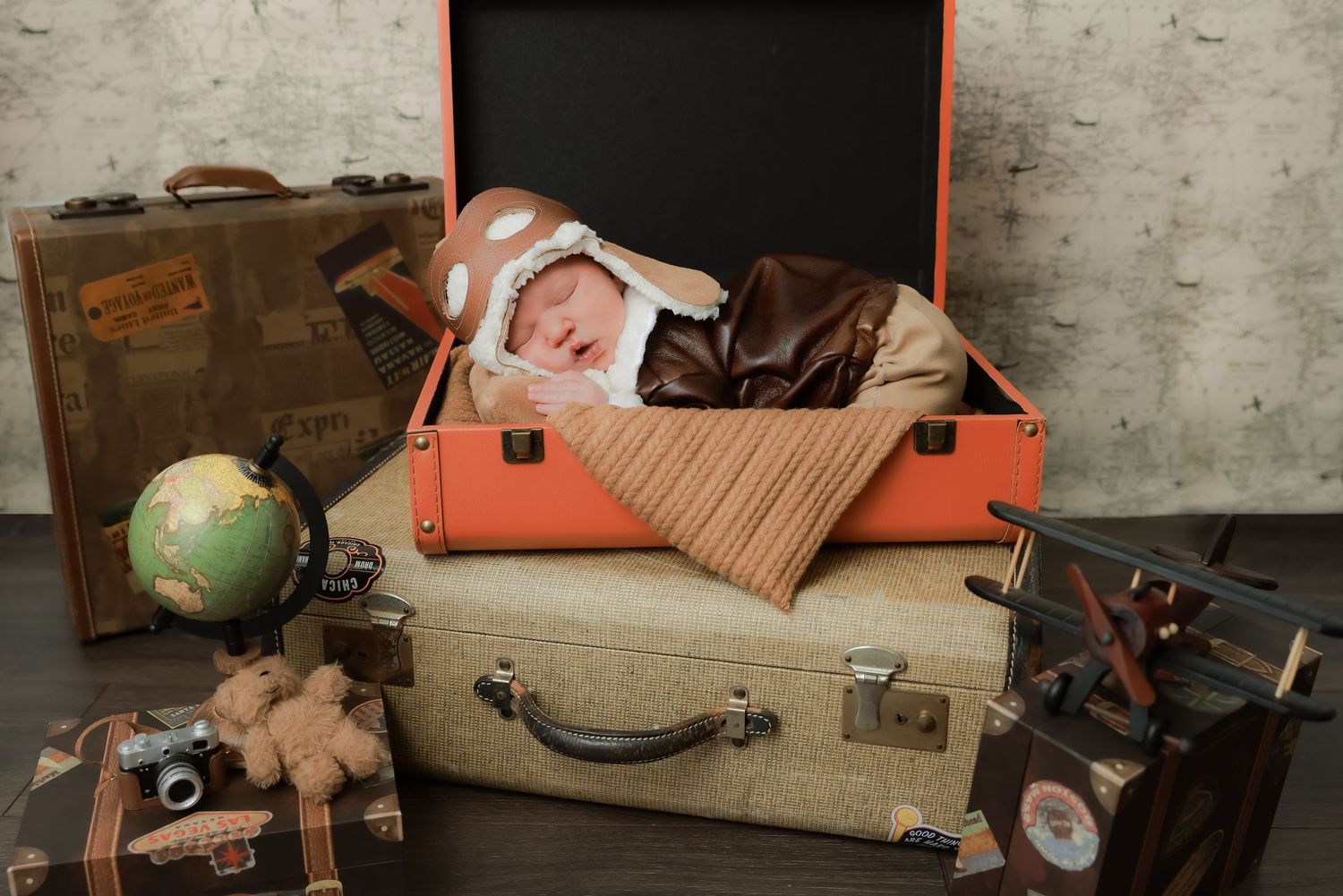 Vintage luggage, suitcases, and travel accessories arranged in a rustic display against a weathered wall.luxury-family-photography-pomona