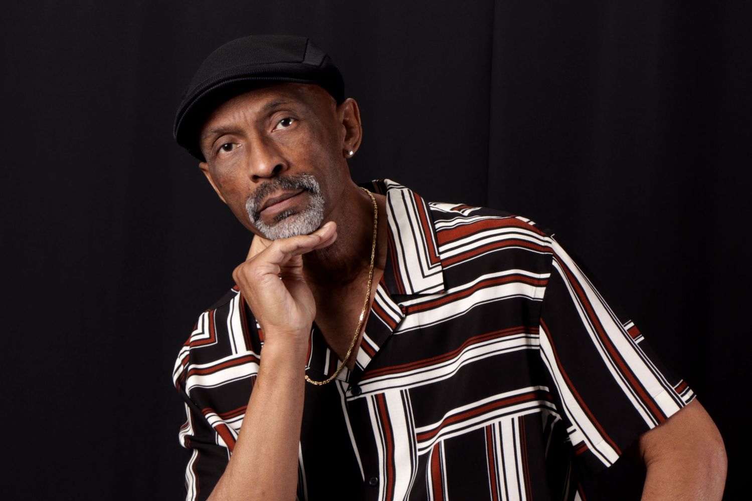 Person in striped shirt and hat poses in black and white photo series.