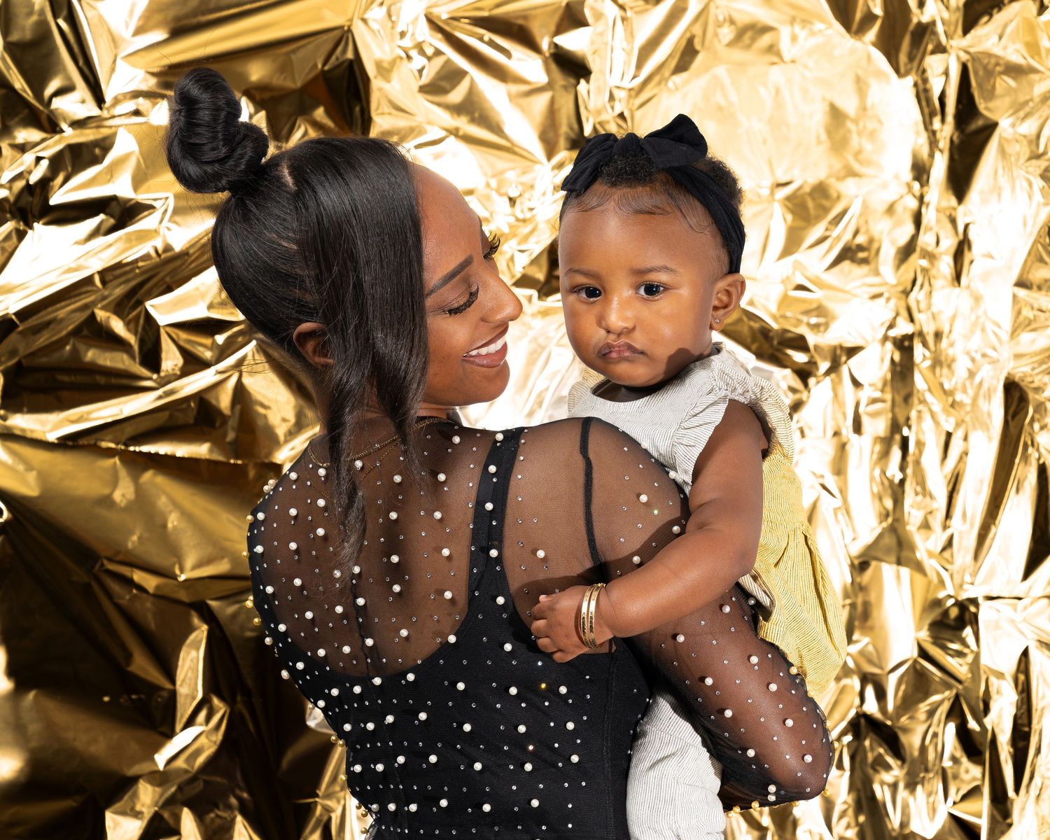 Stylish portrait session against shimmering gold backdrop with dramatic lighting.