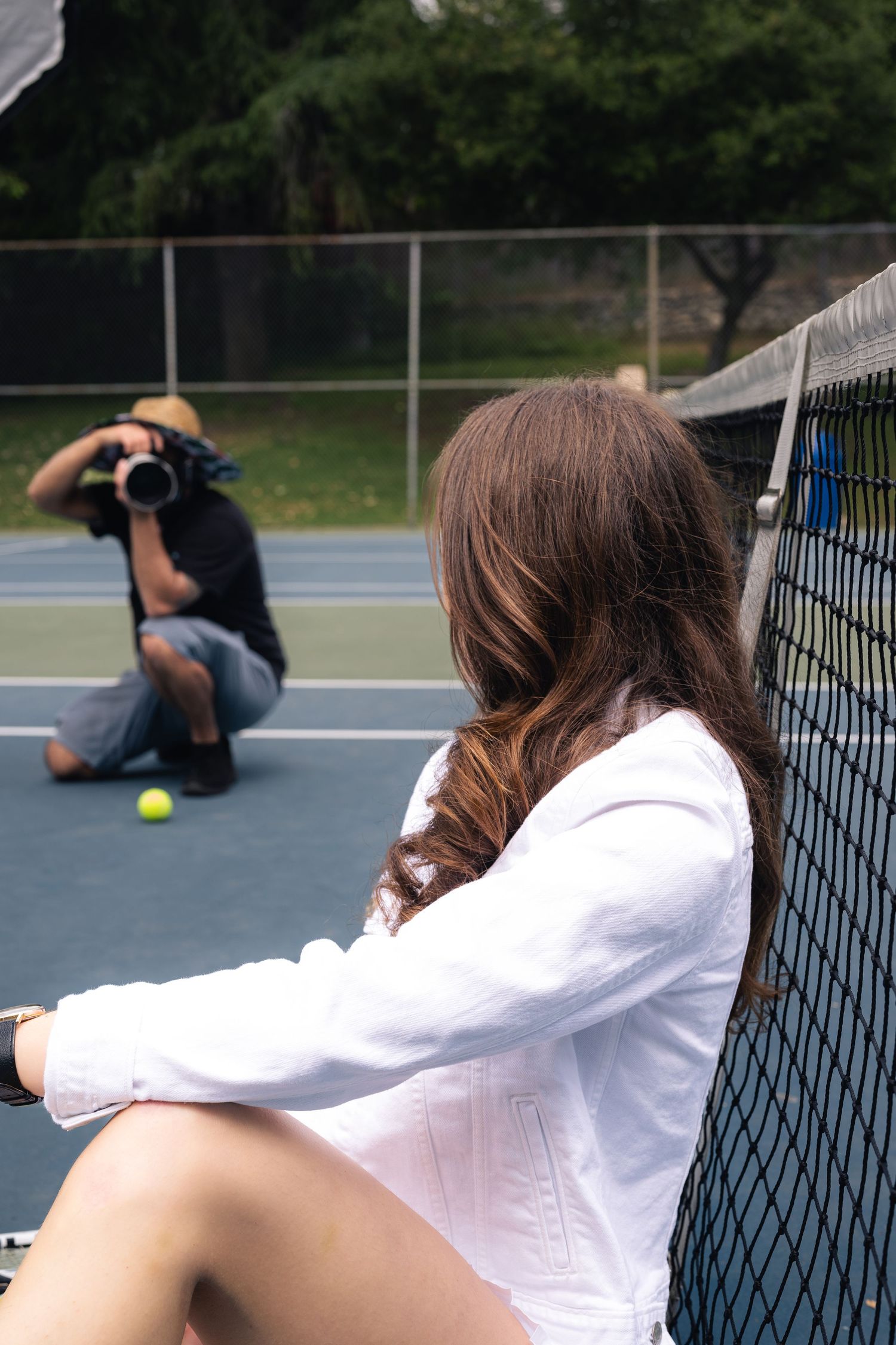 A series of photos shows a tennis player falling down and rolling on a blue court next to the net. luxury-family-photography-Inland empire.