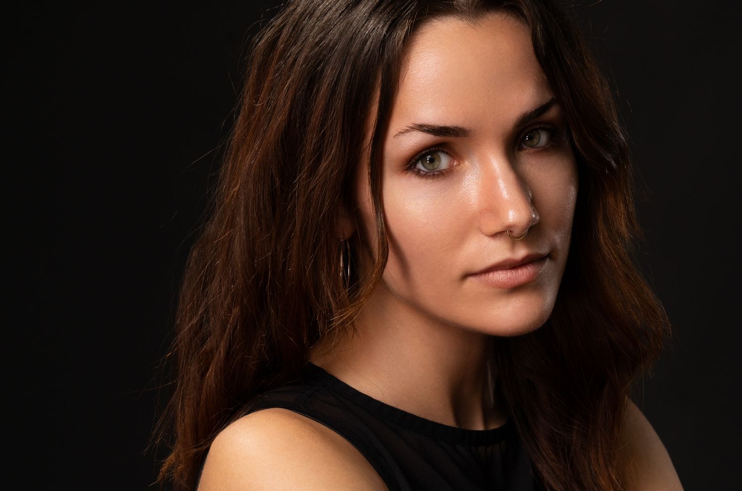 A series of professional portrait photographs showing a woman with brown hair in various poses against a dark background.