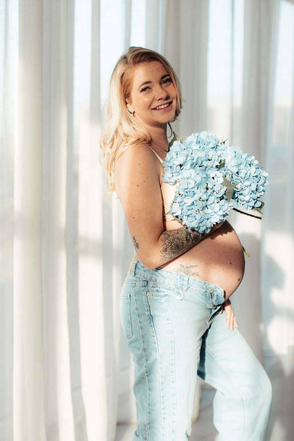 Portrait series with light blue hydrangeas and matching denim against white curtains.